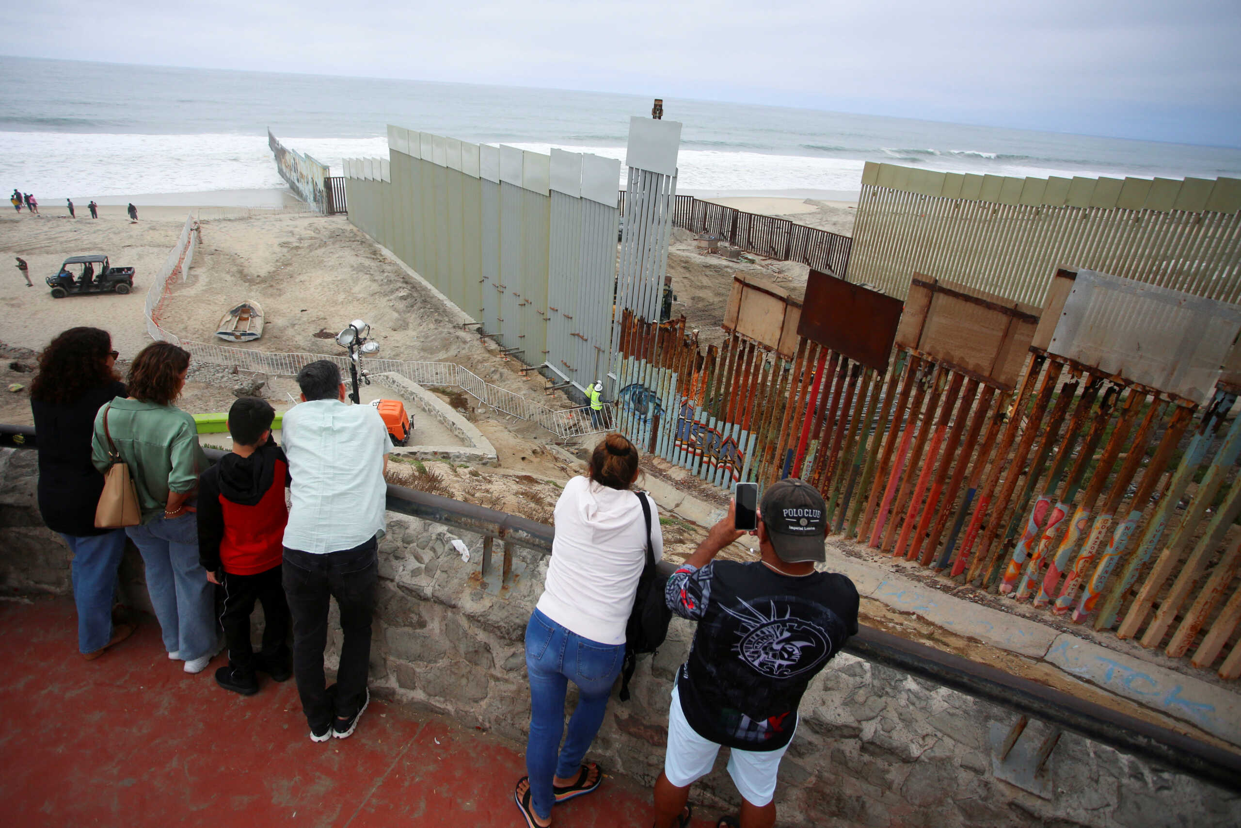 People observe a construction crew working in the replacement of the corroded primary border wall between Mexico and U.S., as seen from Playas de Tijuana, Mexico October 16, 2023. REUTERS