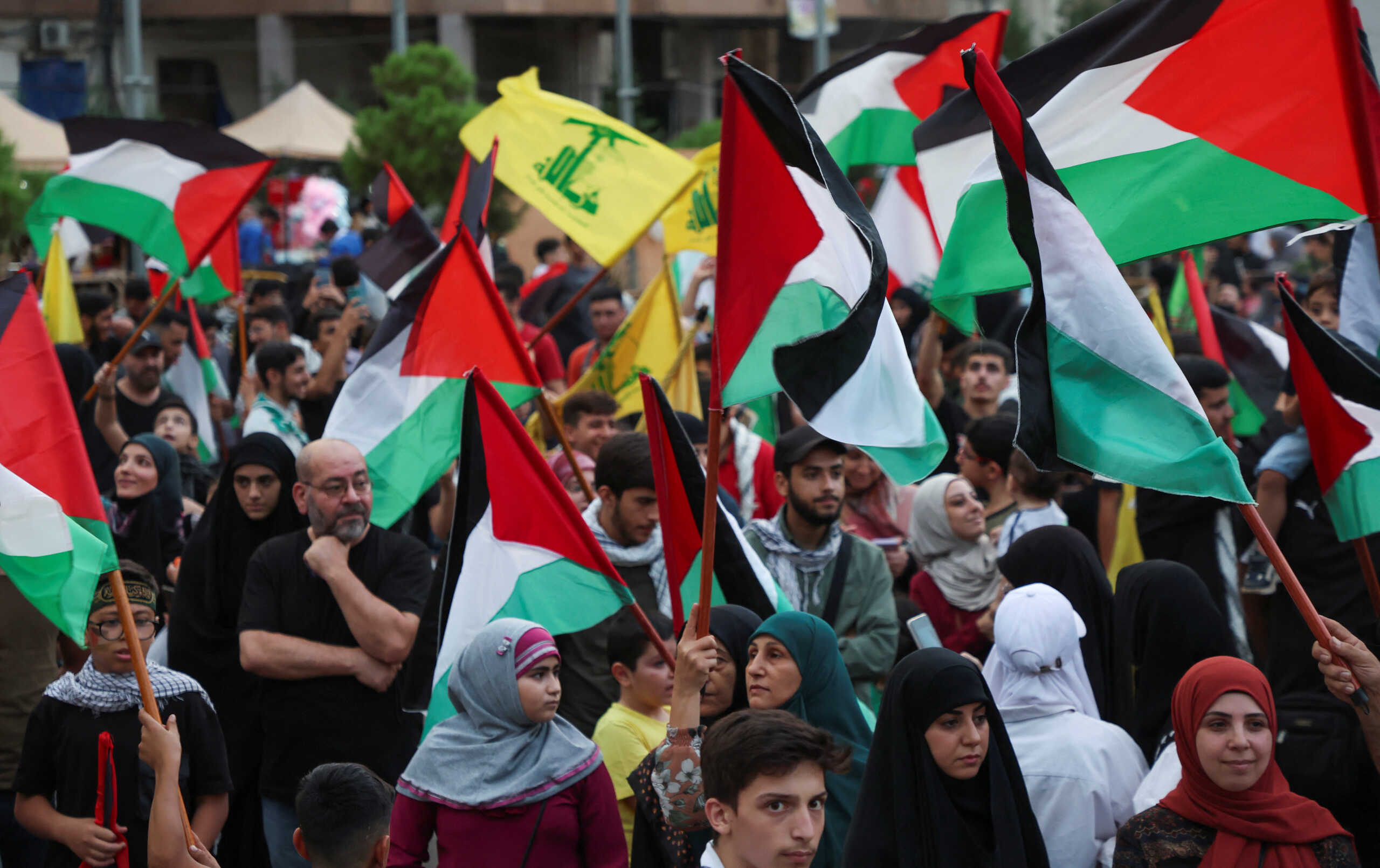 People hold flags to express solidarity with Palestinians in Gaza, in Beirut suburbs, Lebanon October 7, 2023. REUTERS