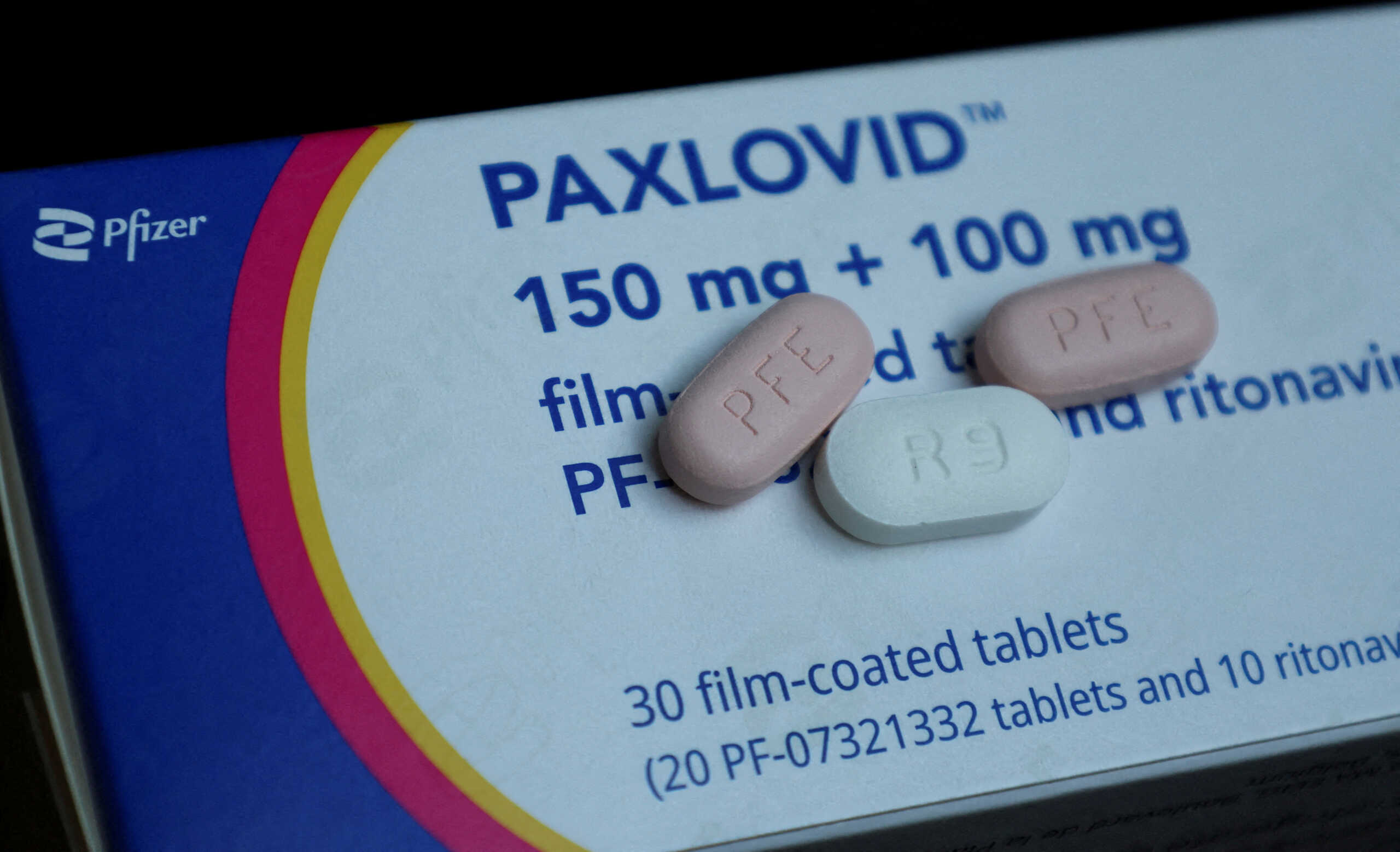 FILE PHOTO: Paxlovid, Pfizer's anti-viral medication to treat the coronavirus disease (COVID-19), is displayed in this picture illustration taken October 7, 2022. A morning and an evening does consists of one white 100-milligram tablet of Ritonavir and two pink 150-milligram tablets of PF-07321332. REUTERS