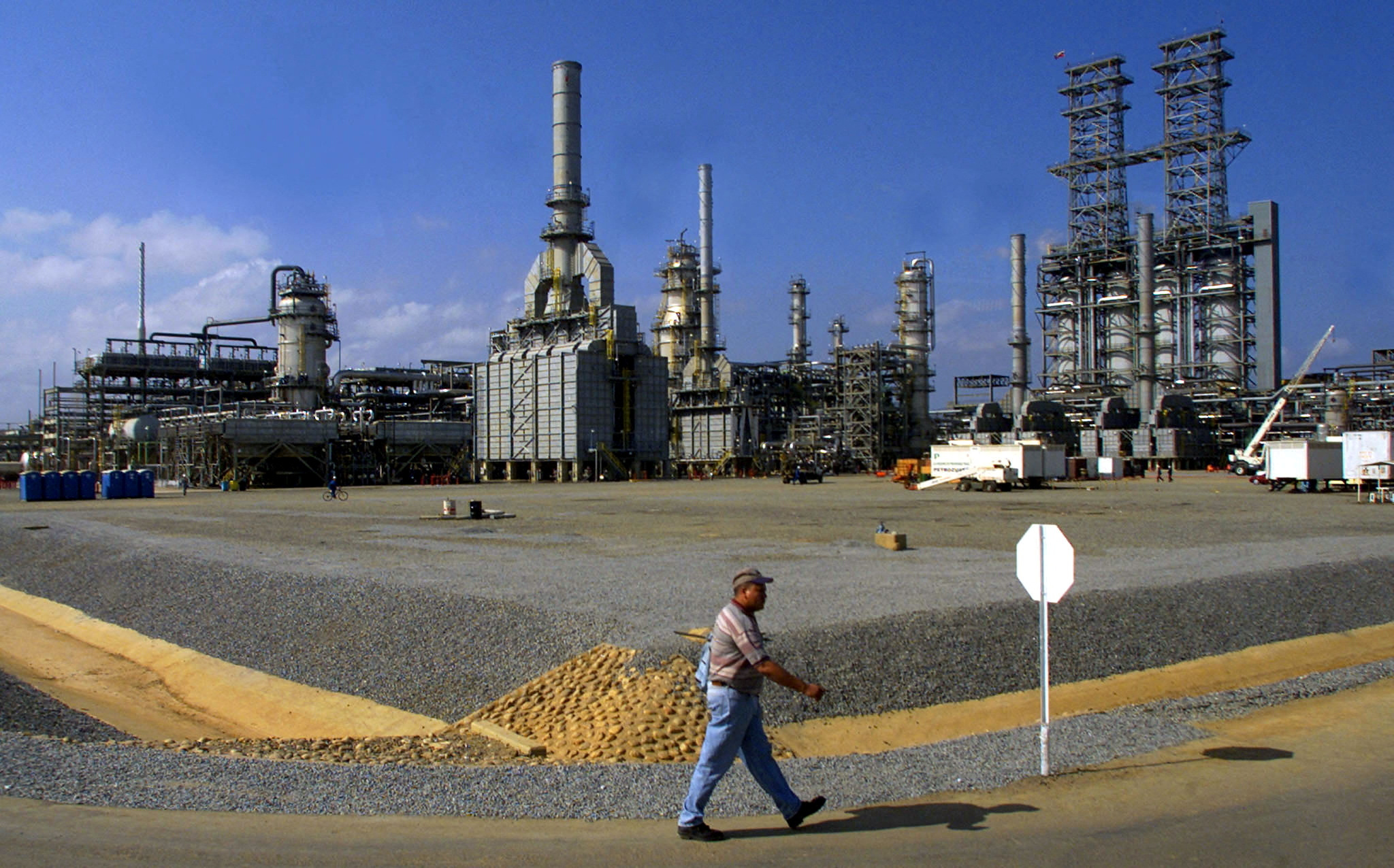 FILE PHOTO: FILE PHOTO: A worker walks past the Petrozuata Oil Refinery in the Orinoco oil belt in the Venezuelan eastern state of Anzoategui, February 13, 2001.