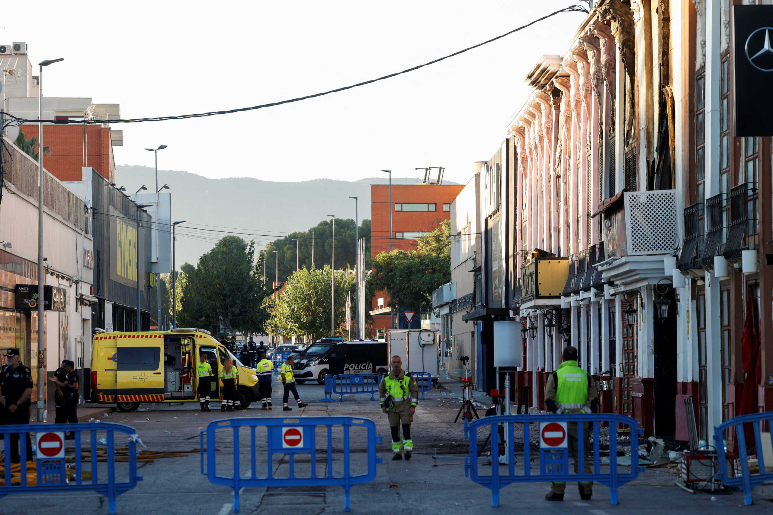 Firefighters walk outside after adjoining nightclubs caught fire in Murcia, Spain, October 2, 2023. REUTERS