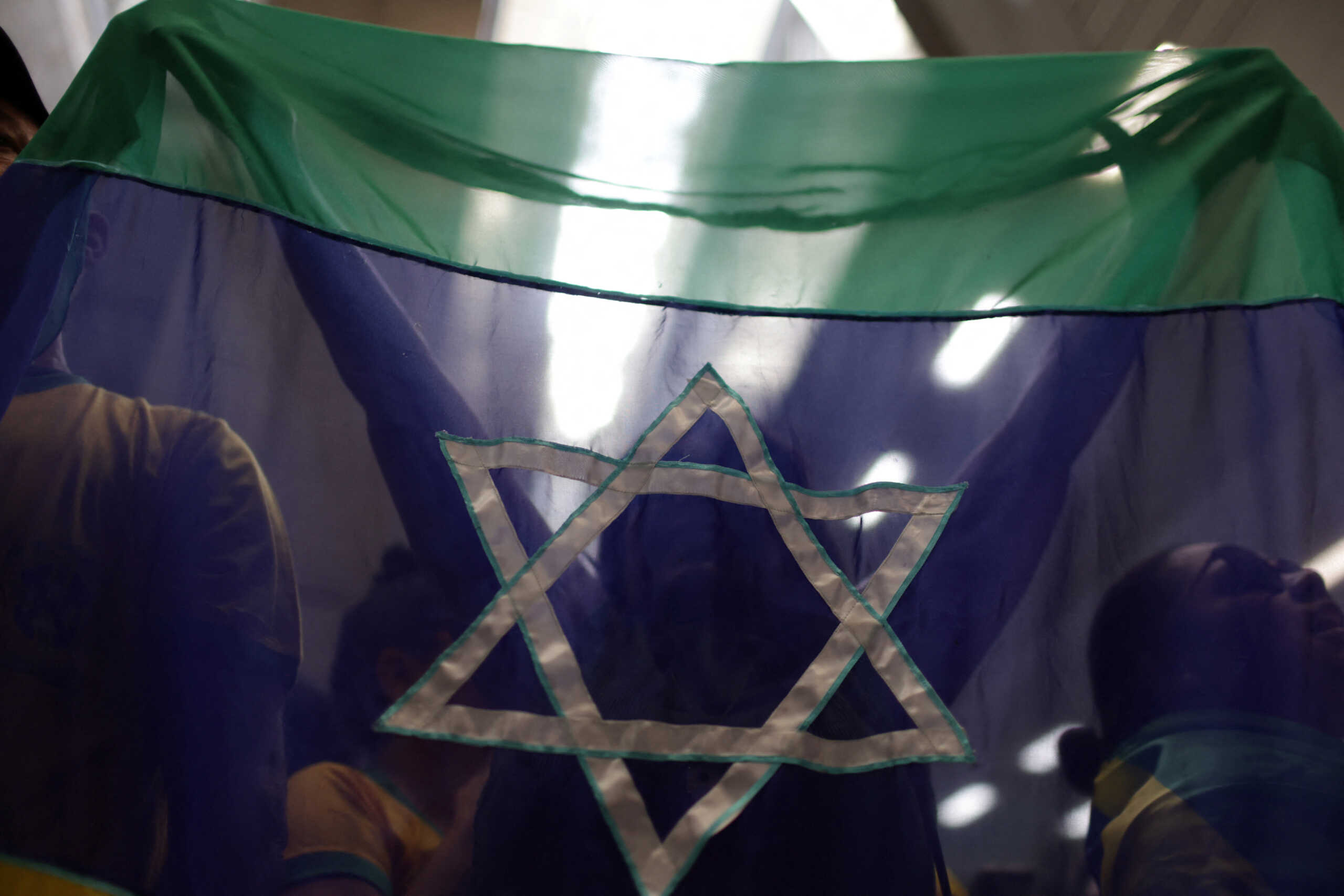 A woman waits for Brazilian citizens, who were repatriated from Israel, holding a flag with the Star of David, at Rio de Janeiro’s international airport, Brazil October 11, 2023. REUTERS