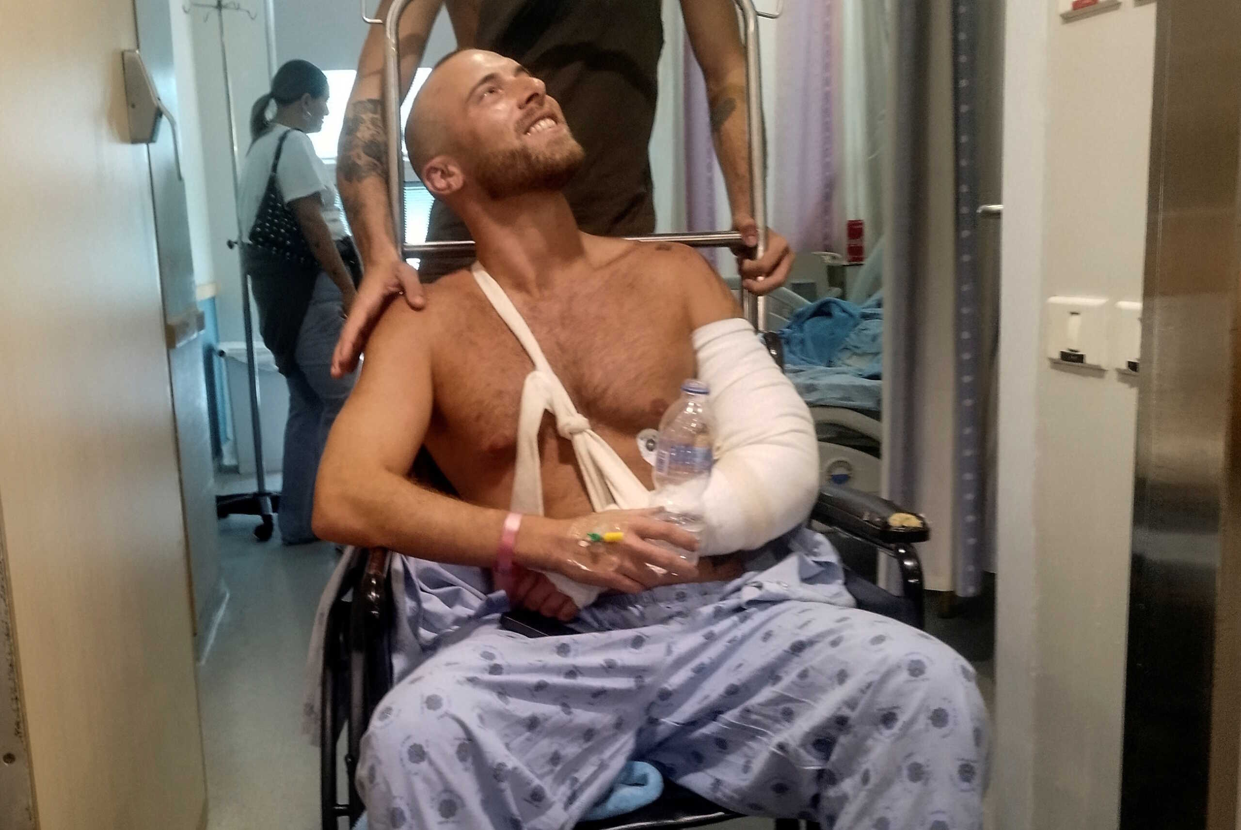 Sahar Ben Sela, survivor of a deadly attack at a festival in southern Israel conducted by Hamas fighters from Gaza, sits in a wheelchair by a friend as he recovers at Ichilov Hospital in Tel Aviv, Israel, October 9, 2023. REUTERS