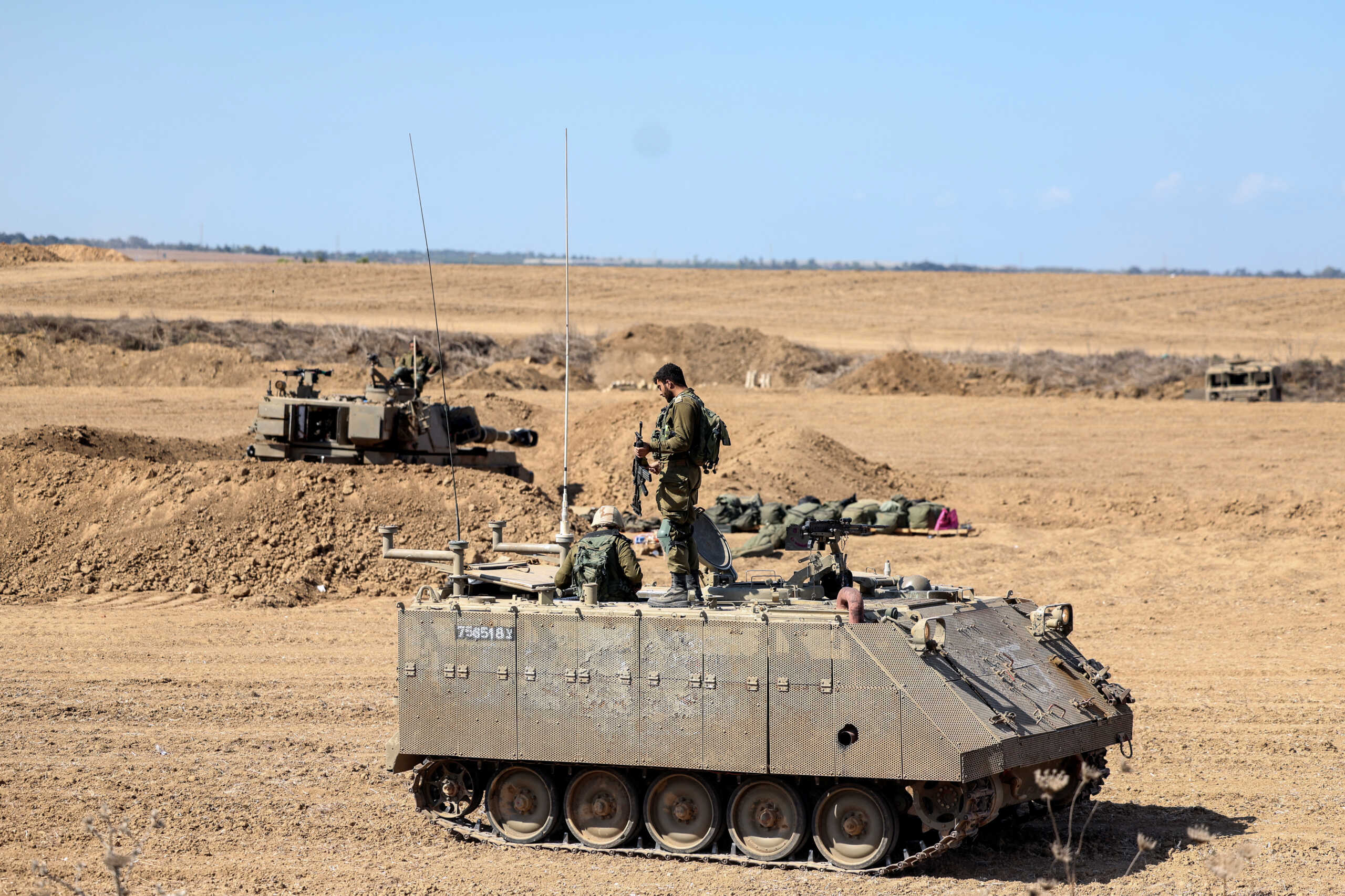 Israeli soldiers are seen on top of an Armoured Personnel Carrier (APC) near Israel's border with the Gaza Strip, in southern Israel October 15, 2023. REUTERS