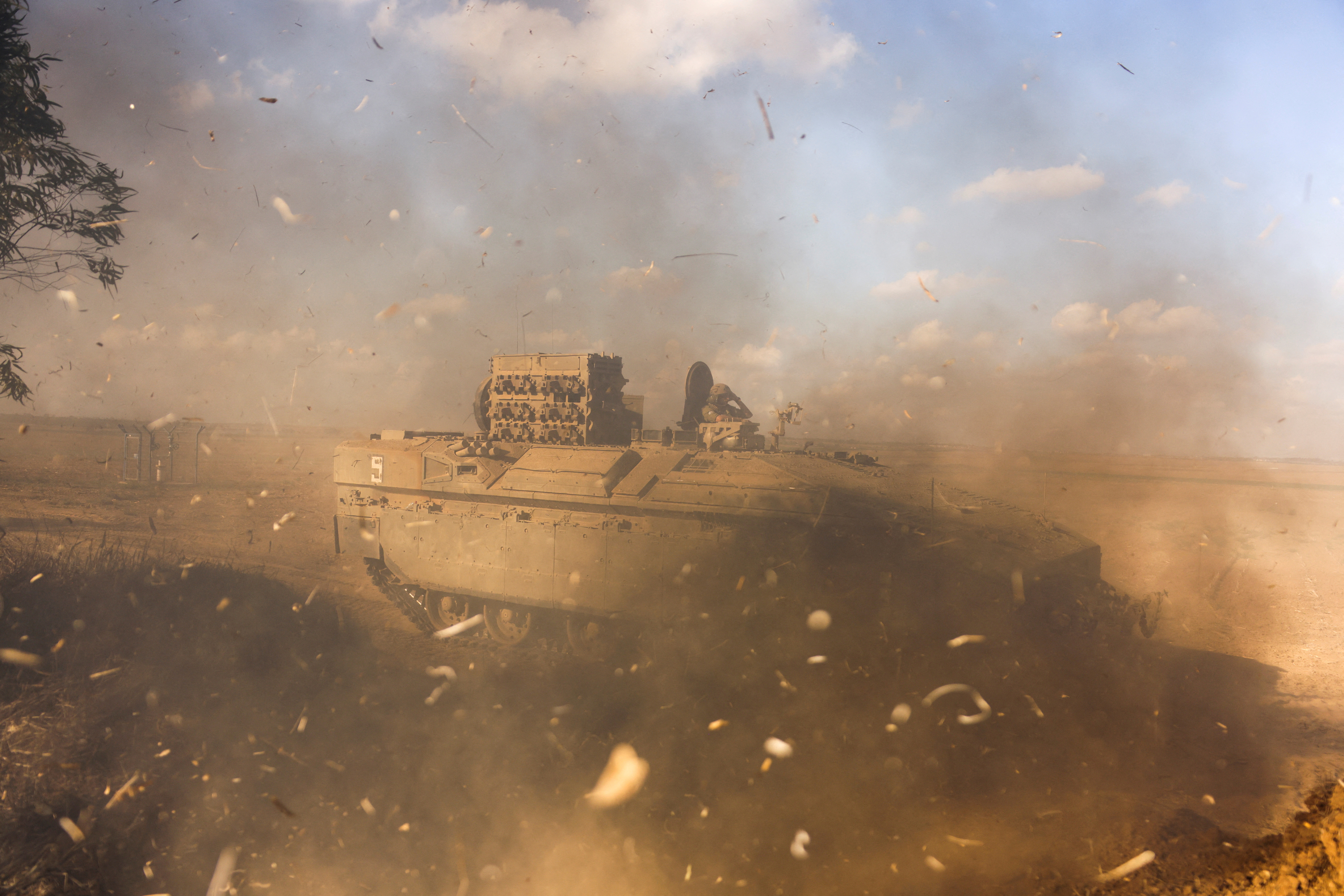 An Israeli armoured personnel carrier (APC) is obscured as it whips up dust near Israel's border with the Gaza Strip, in southern Israel October 15, 2023. REUTERS