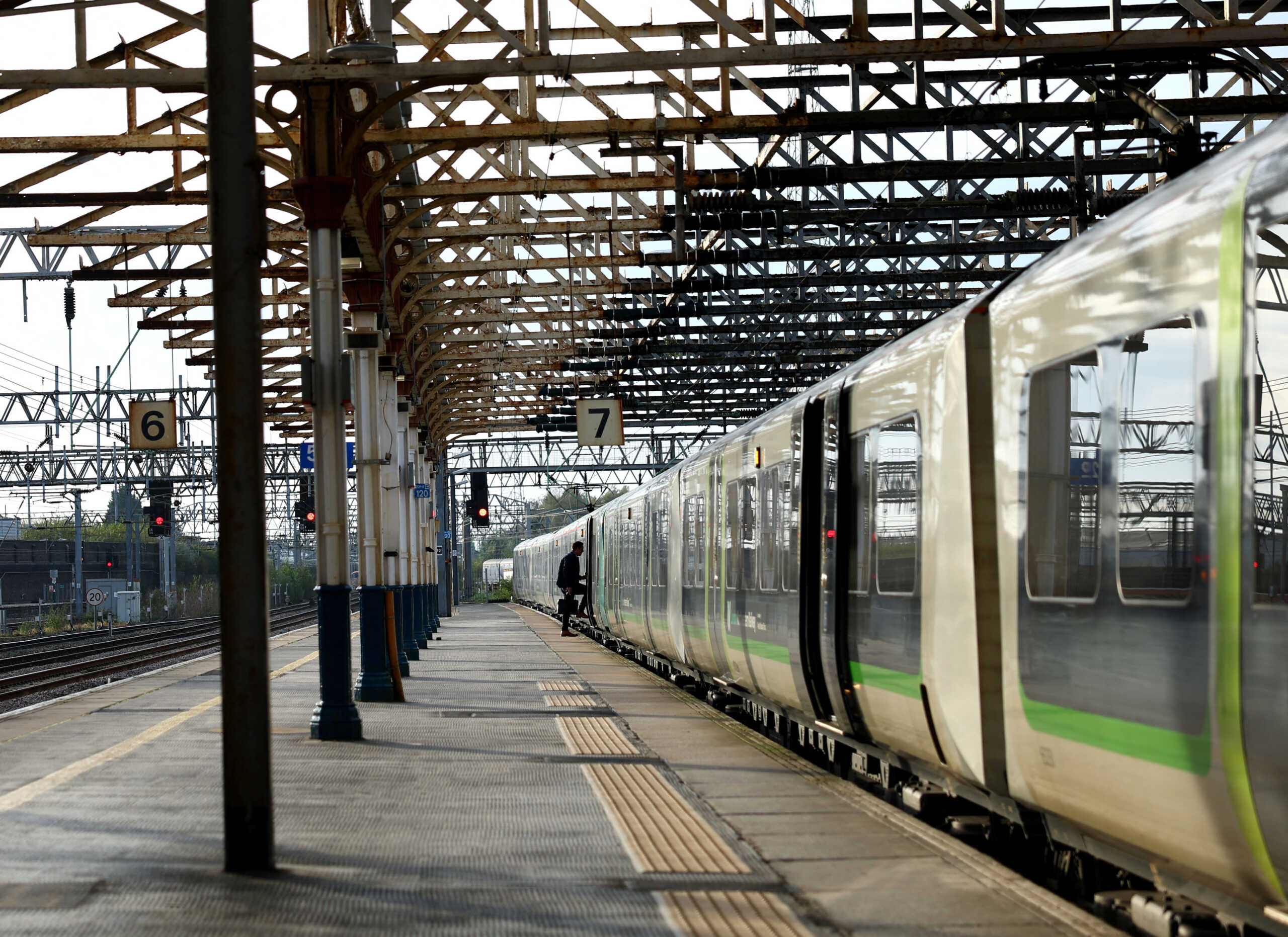 A man boards a train on a platform at Crewe Station in Crewe, Britain, October 18, 2023. REUTERS