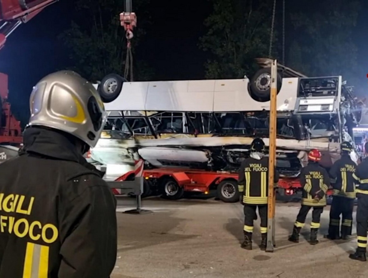 epa10898918 A handout photo made available by Vigili del Fuoco (Italy's Firefighters) shows the removal of the wreckage of a bus after it fell off an overpass the previous night, in Mestre, near Venice, Italy, early 04 October 2023. At least 21 people died in the accident on 03 October and 15 others were injured.  EPA