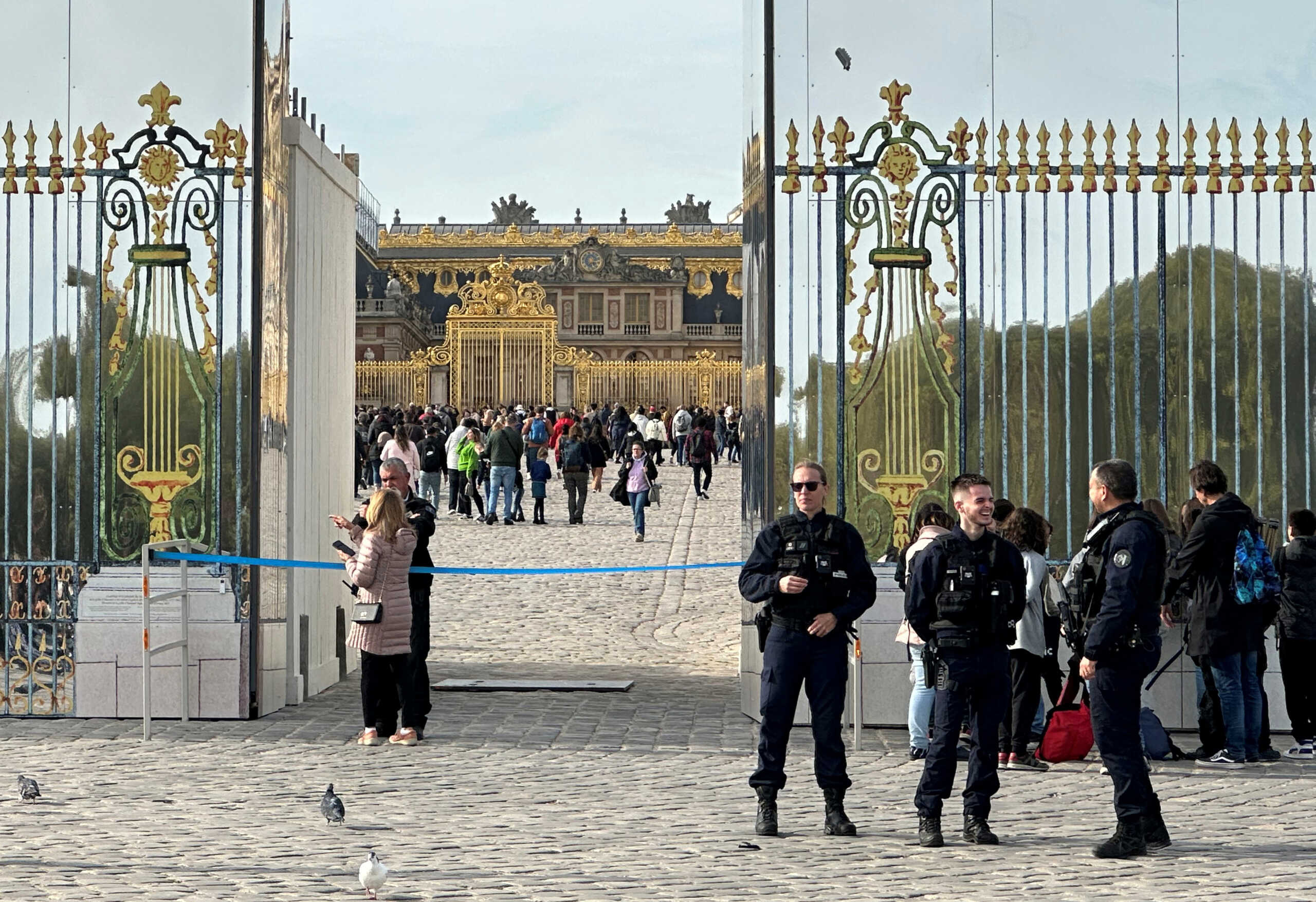 French police stand guard in front of the Chateau de Versailles (Versailles Palace) as tourists enter again after the Palace was evacuated for security reasons, in Versailles, near Paris, France, October 17, 2023. REUTERS