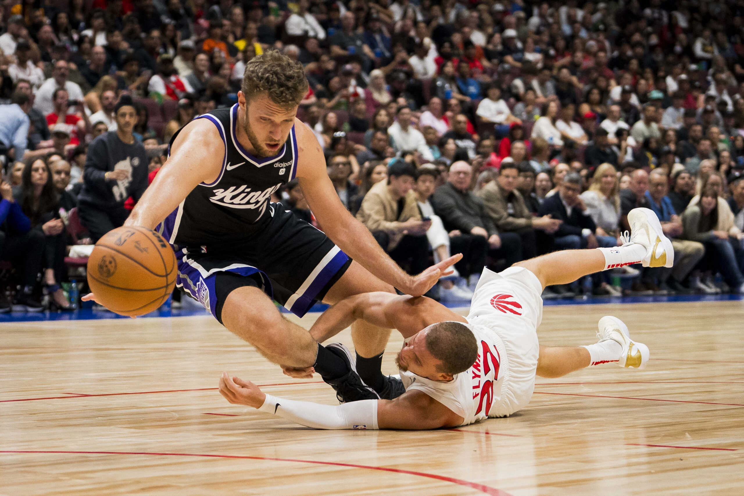 Oct 8, 2023; Vancouver, British Columbia, CAN; Toronto Raptors guard Malachi Flynn (22) and Sacramento Kings forward Sasha Vezenkov (7) battle for the loose ball in the second half at Rogers Arena. Raptors won 112-99. Mandatory Credit: Bob Frid-USA TODAY Sports