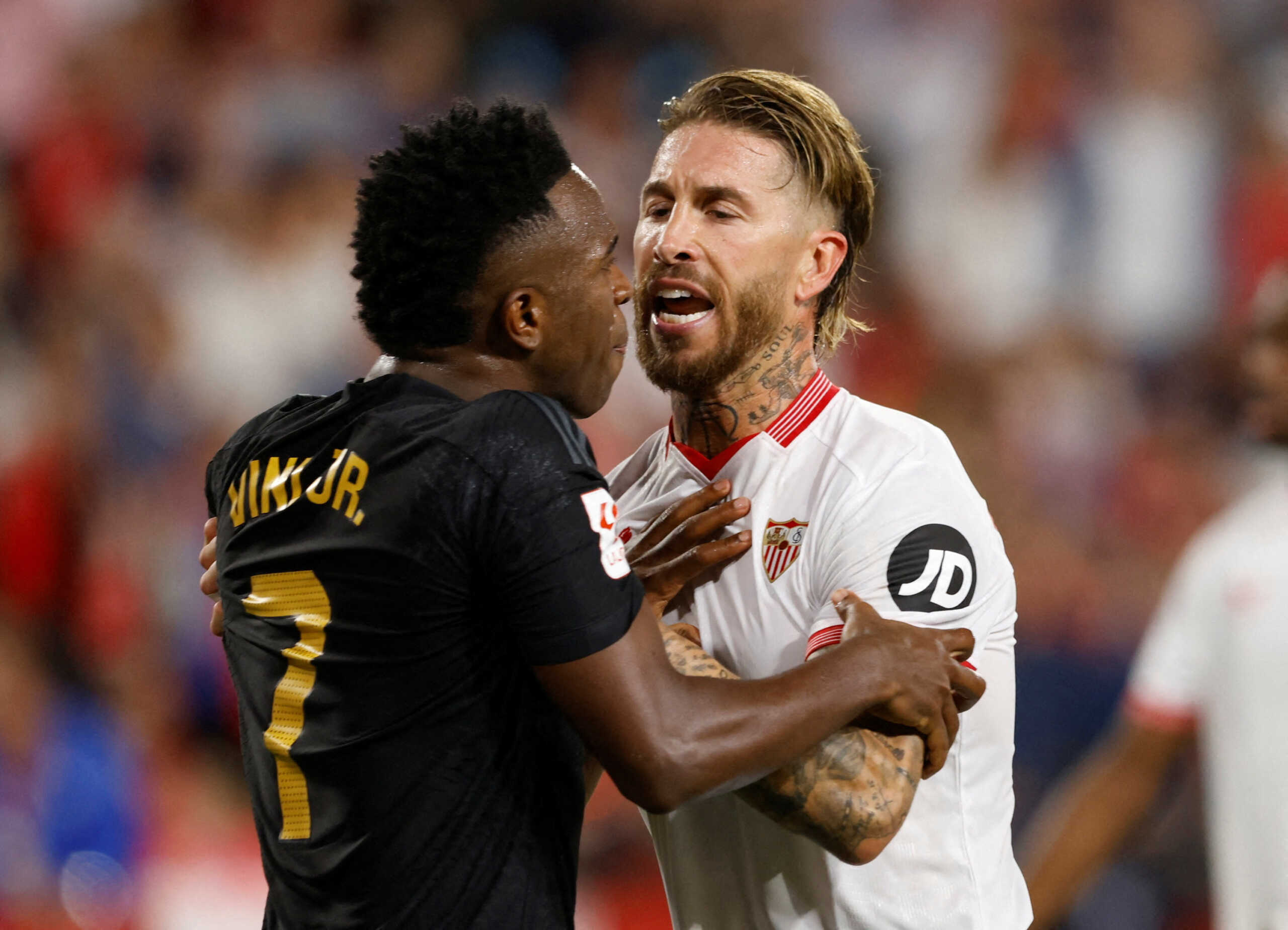 Soccer Football - LaLiga - Sevilla v Real Madrid - Ramon Sanchez Pizjuan, Seville, Spain - October 21, 2023 Real Madrid's Vinicius Junior is held by Sevilla's Sergio Ramos as he clashes with Sevilla players REUTERS