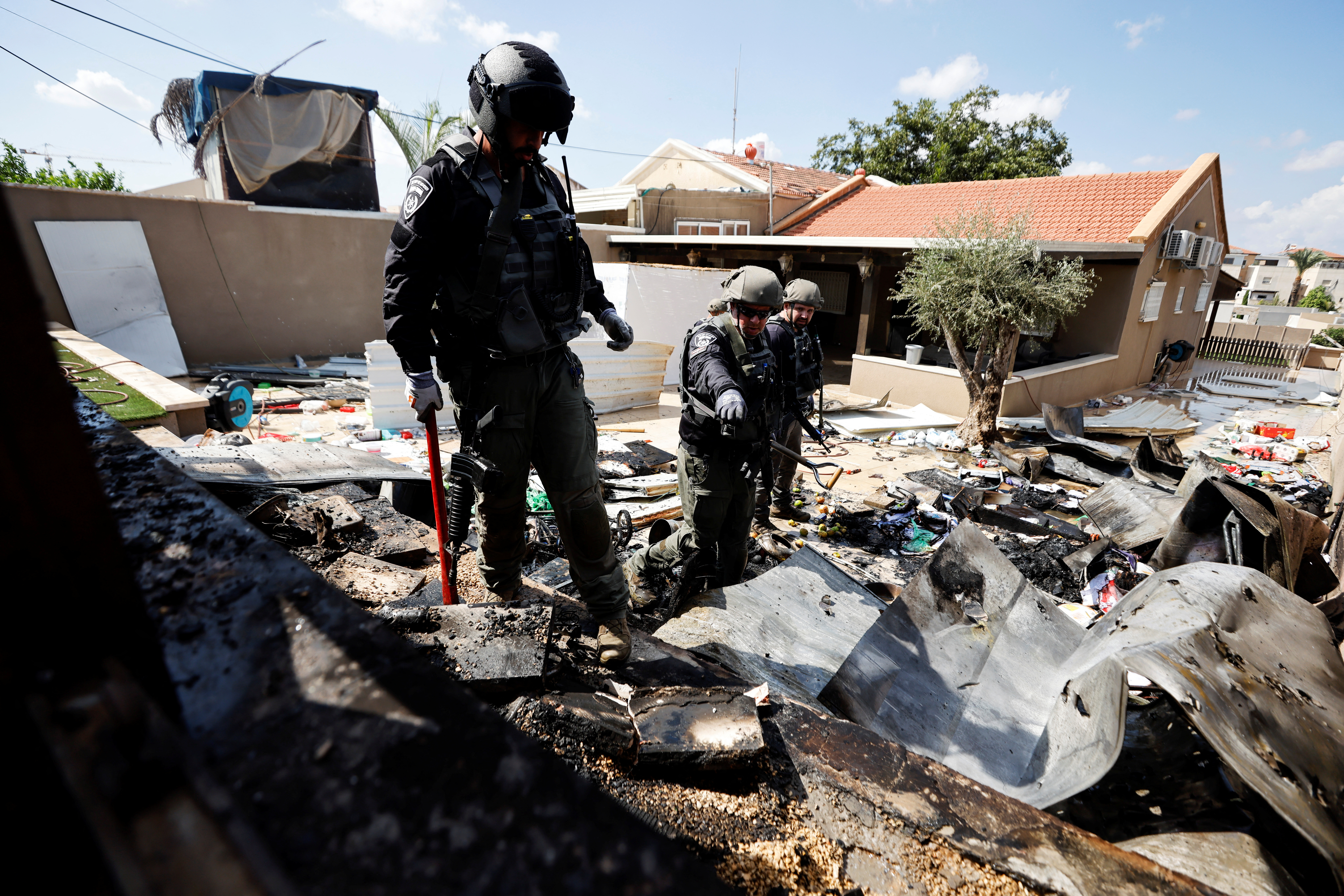 Israeli police explosive experts survey the remains of a private house after it was hit by a rocket launched from the Gaza Strip into Israel, in Sderot, southern Israel October 15, 2023. REUTERS
