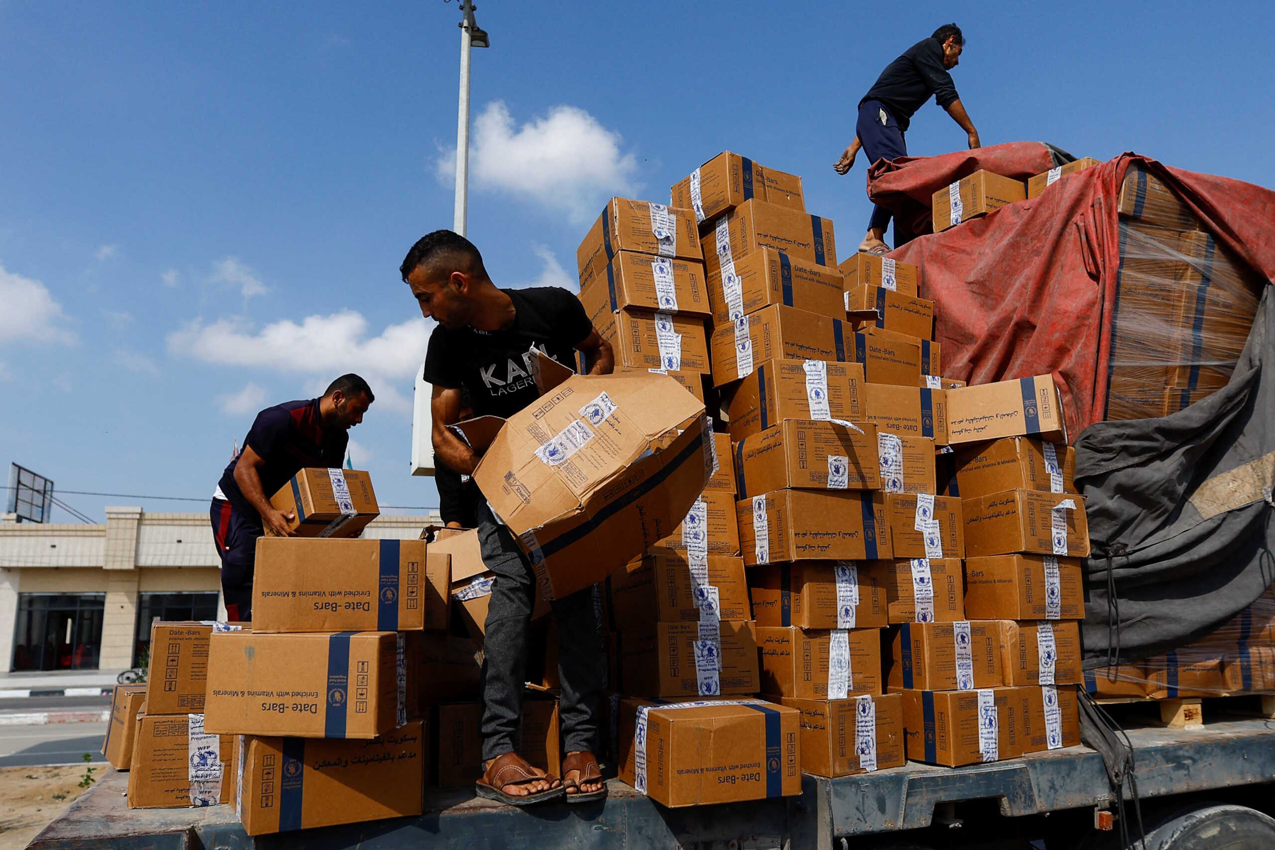 Palestinians reload a truck with aid that fell from the vehicle, amid shortages of food supplies, during the ongoing conflict between Israel and Palestinian Islamist group Hamas, in Rafah in the southern Gaza Strip, November 2, 2023. REUTERS