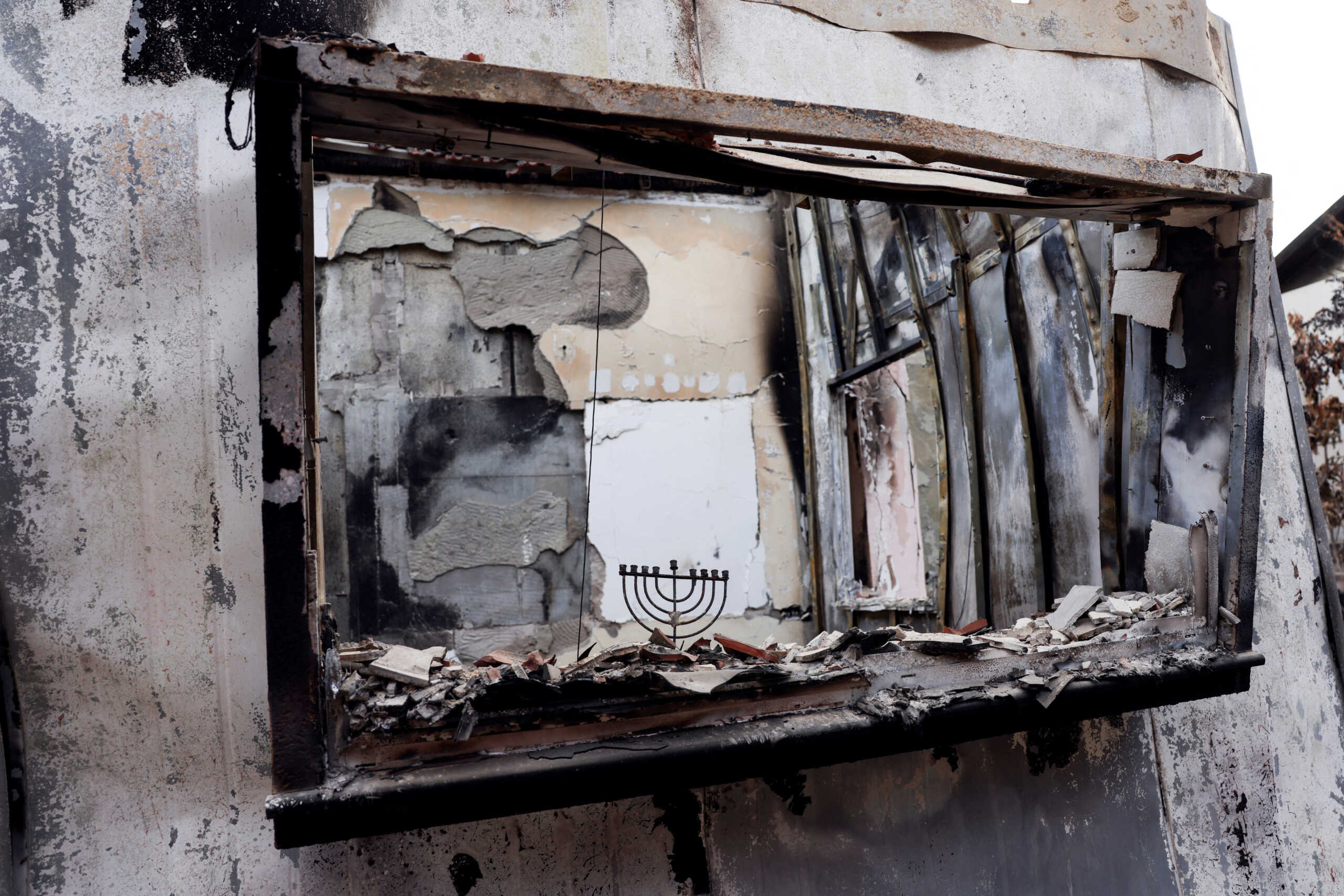 FILE PHOTO: A Hanukkiyah, a candlestick used during the Jewish holiday of Hanukkah, stands on the remains of a burnt windowsill, following a deadly infiltration by Hamas gunmen from the Gaza Strip, in Kibbutz Beeri in southern Israel October 17, 2023. REUTERS