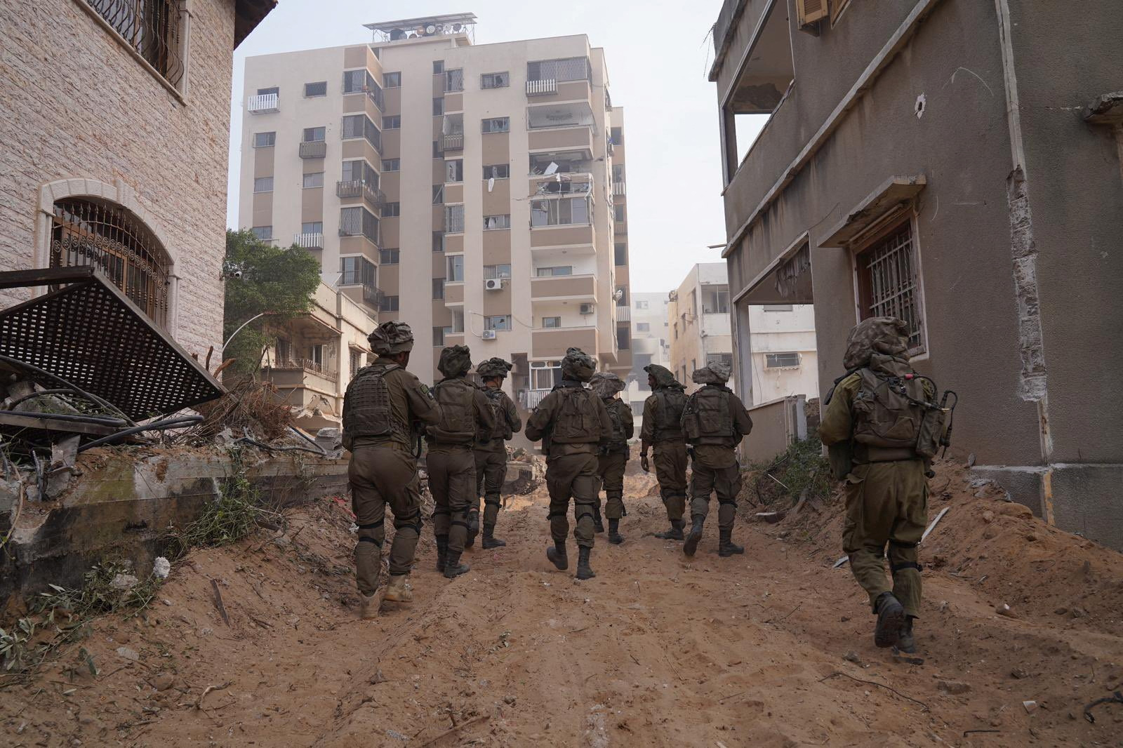 Israeli soldiers walk during the ongoing ground operation of the Israeli army against Palestinian Islamist group Hamas, in the Gaza Strip as seen in a handout picture released by the Israel Defense Forces on November 13, 2023. Israel Defense Forces