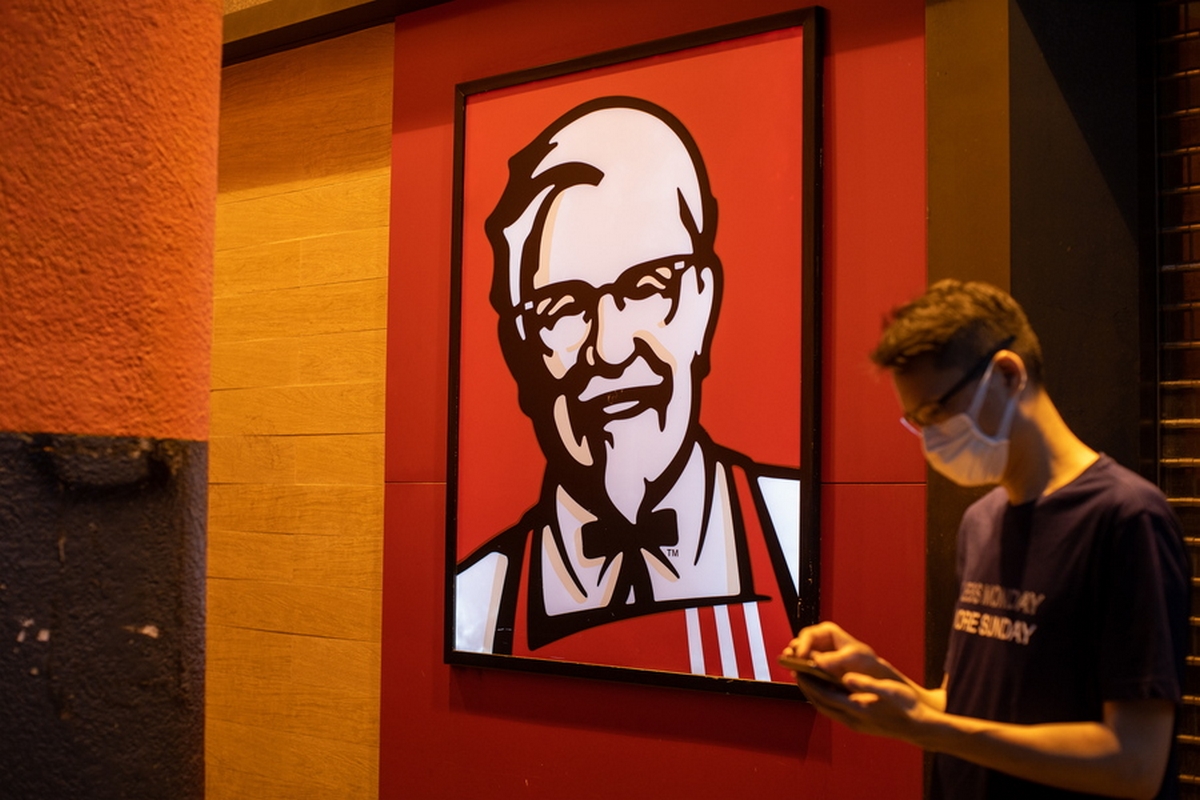 epa08246402 A man looks at his phone while standing next to a closed Kentucky Fried Chicken fast-food branch in Hong Kong, China, 25 February 2020. KFC said it has shut down its branch in North Point after a staff member of staff and her son were confirmed to have caught the Covid-19 virus.  EPA