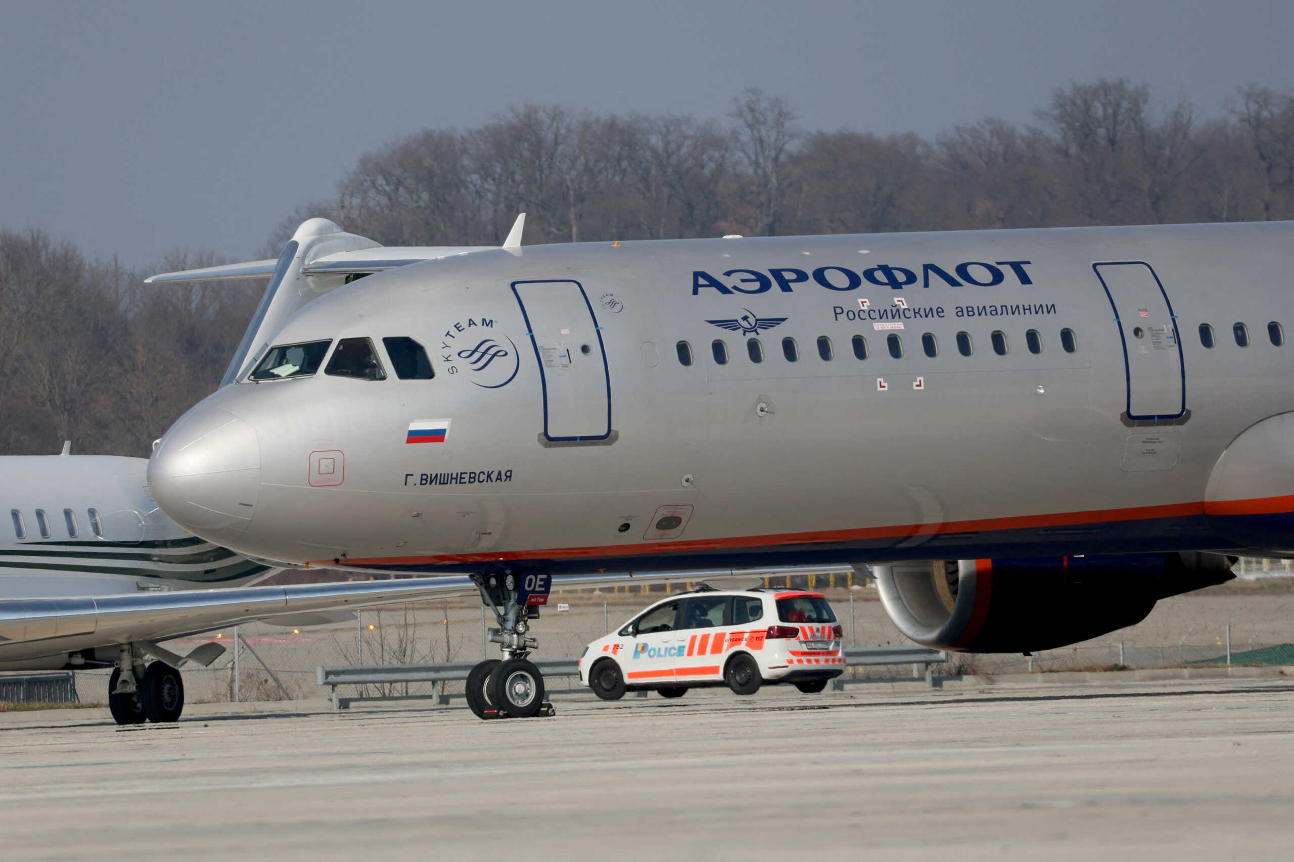 FILE PHOTO: A police vehicle drives behind an Airbus A321-211 aircraft of Russian airline Aeroflot with registration VP-BOE on a long term parking at Cointrin airport in Geneva, Switzerland, March 9, 2022. REUTERS