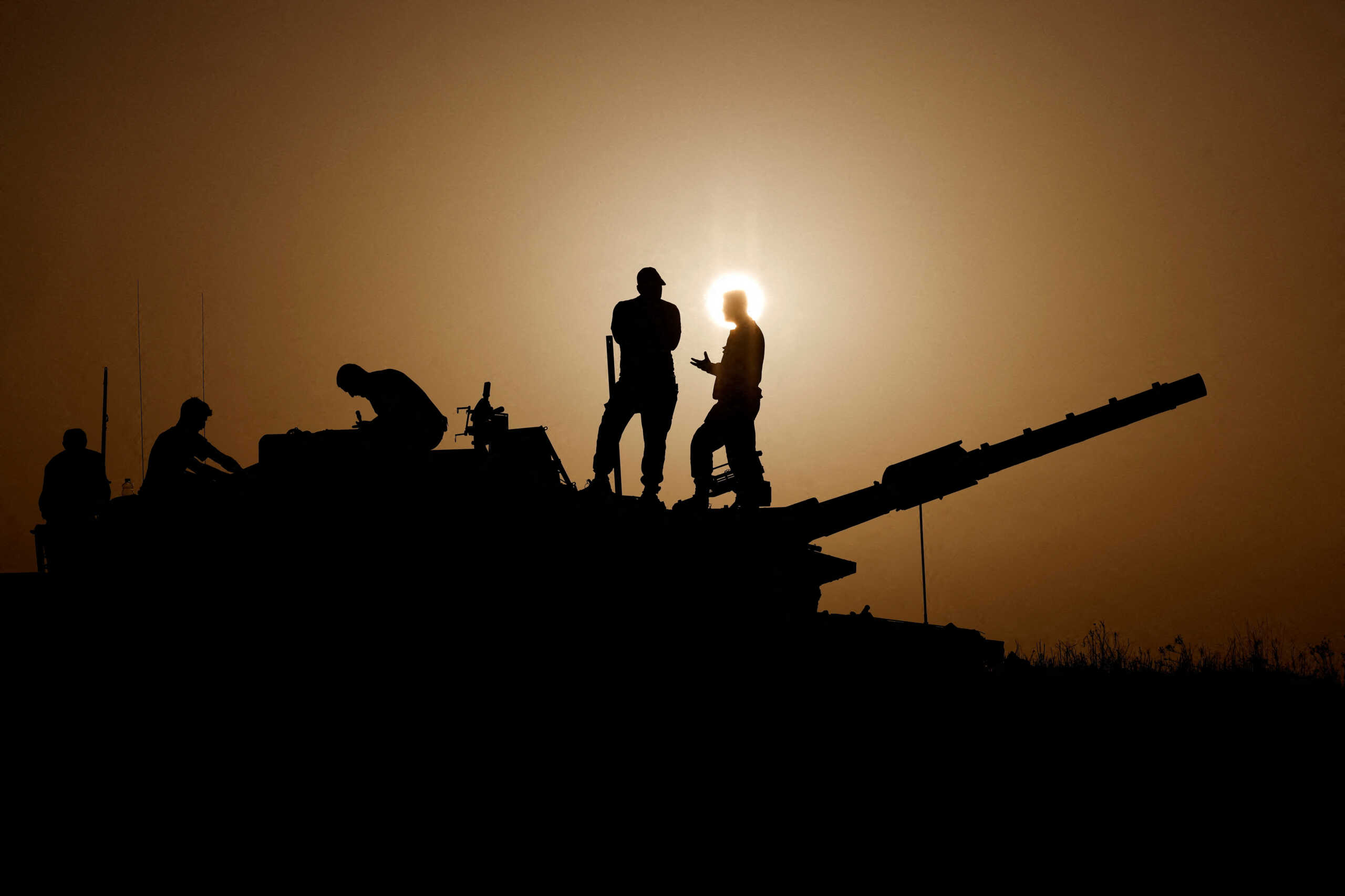 Israeli soldiers stand on a tank, amid the ongoing conflict between Israel and the Palestinian group Hamas, near Israel's border with Gaza in southern Israel, November 23, 2023. REUTERS