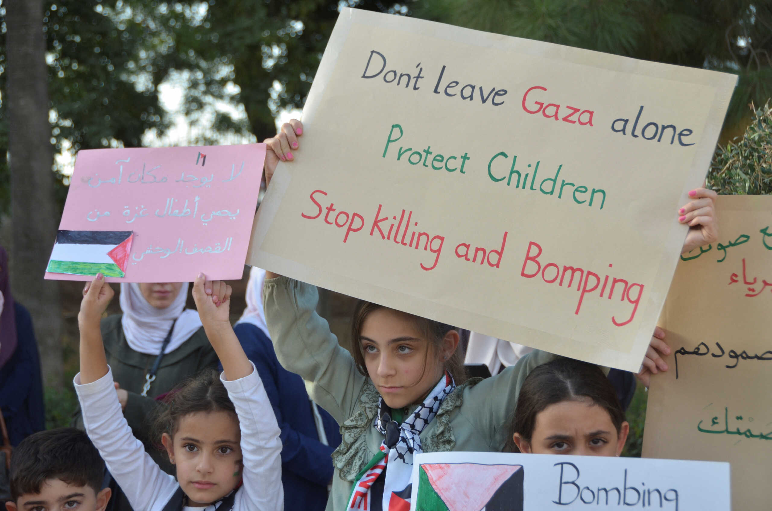 Children hold placards in a show of support for Gazan children in the besieged enclave, during the Israeli-Hamas conflict, in Amman, Jordan October 22, 2023. REUTERS