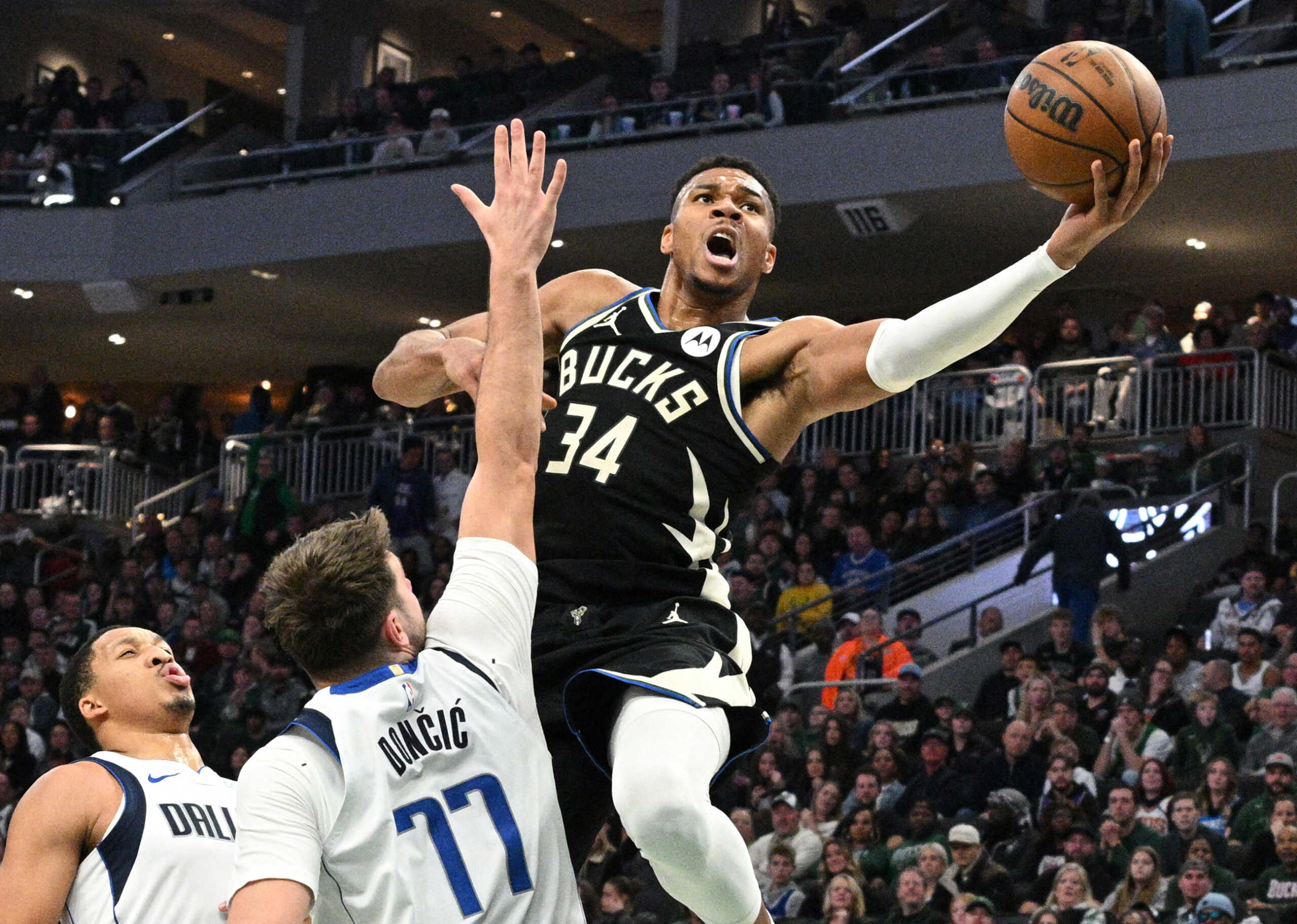 Nov 18, 2023; Milwaukee, Wisconsin, USA; Milwaukee Bucks forward Giannis Antetokounmpo (34) drives to the basket against Dallas Mavericks guard Luka Doncic (77) in the first half at Fiserv Forum. Mandatory Credit: Michael McLoone-USA TODAY Sports