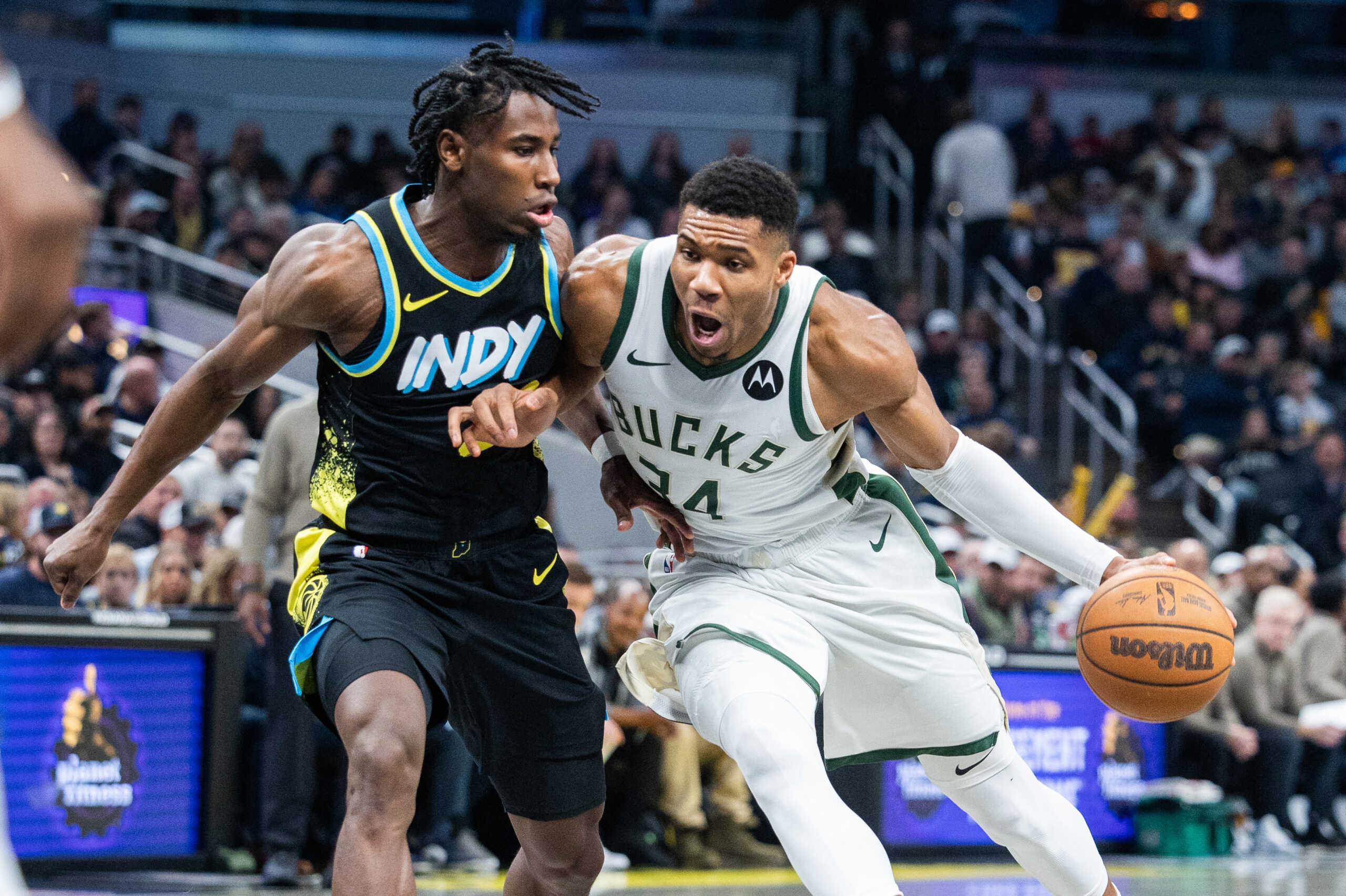Nov 9, 2023; Indianapolis, Indiana, USA; Milwaukee Bucks forward Giannis Antetokounmpo (34) dribbles the ball while Indiana Pacers forward Aaron Nesmith (23) defends in the first quarter at Gainbridge Fieldhouse. Mandatory Credit: Trevor Ruszkowski-USA TODAY Sports