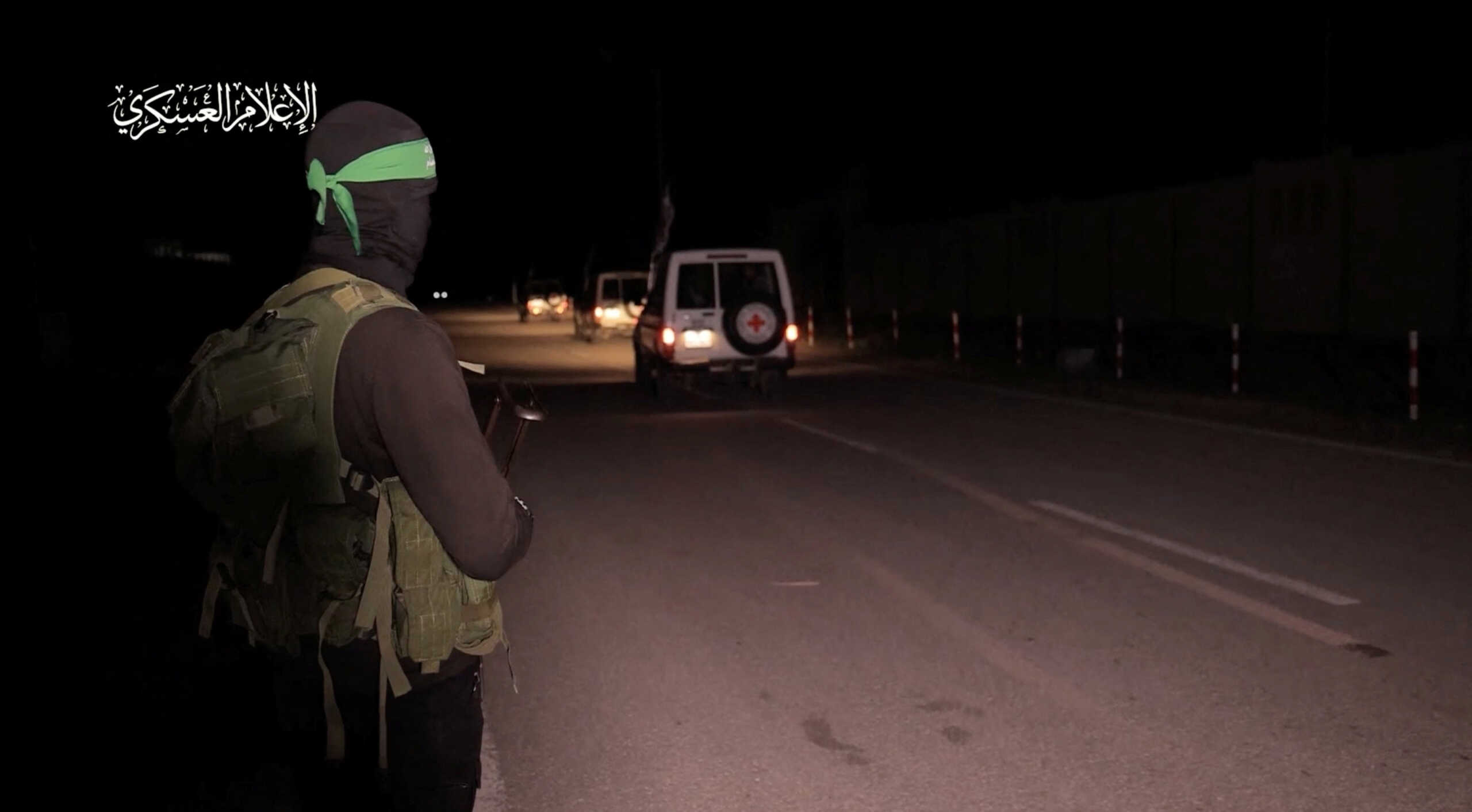 A Hamas militant looks on as vehicles of the International Committee of the Red Cross depart after hostages who were abducted by Hamas gunmen during the October 7 attack on Israel, weree handed over by Hamas militants to members of the International Committee of the Red Cross, as part of a hostages-prisoners swap deal between Hamas and Israel amid a temporary truce, in an unknown location in the Gaza Strip, in this screengrab taken from video released November 27, 2023. Hamas Military Wing