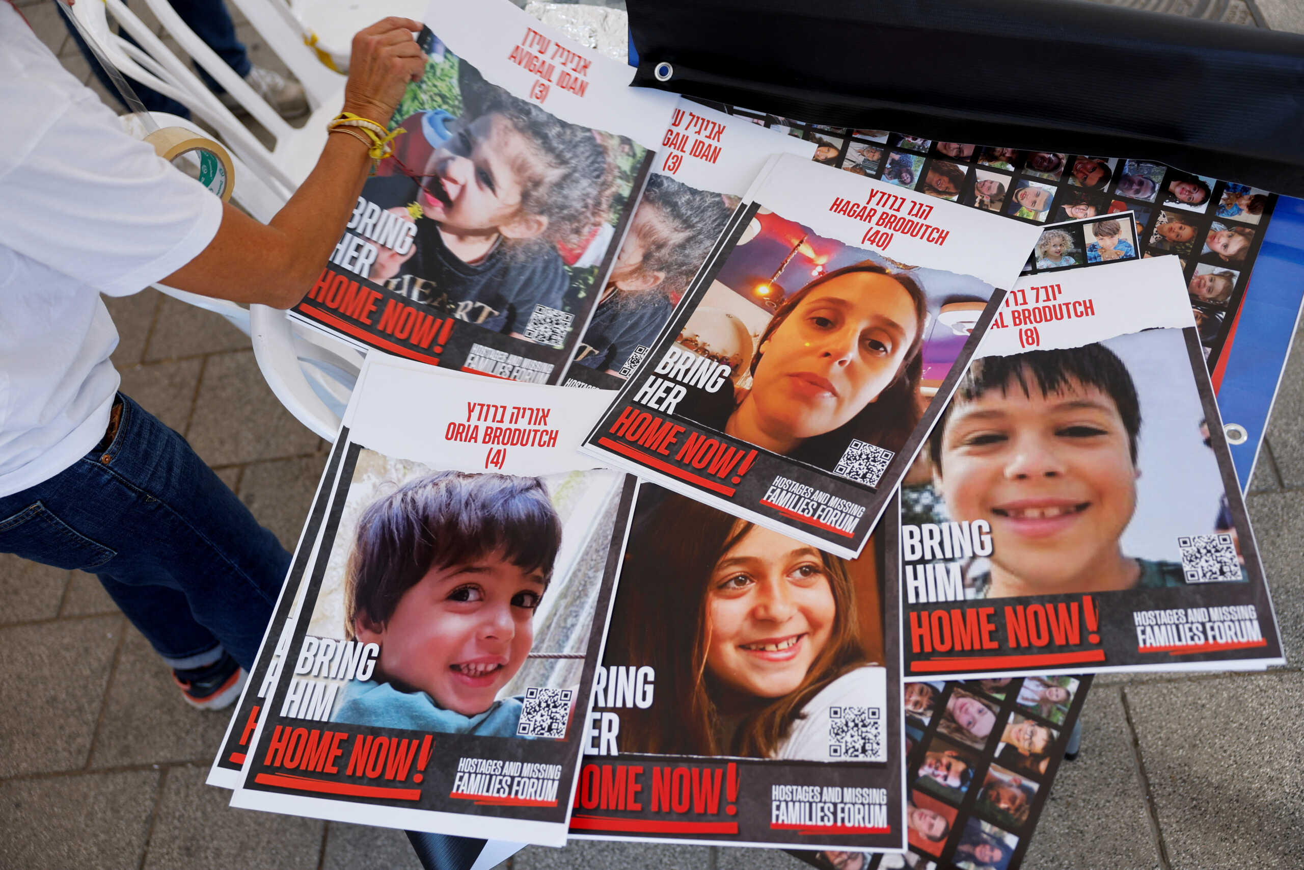 A supporter of the families of hostages who are being held in the Gaza Strip after they were seized by Hamas gunmen on October 7 prepares missing signs posters depicting hostages, in Tel Aviv, Israel November 21, 2023. REUTERS