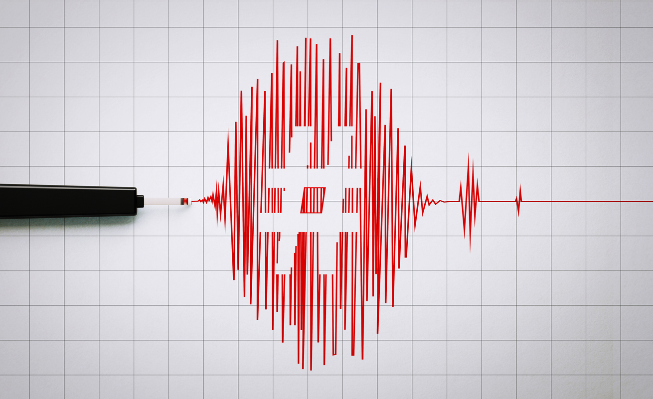 Seismograph recording seismic activity and hashtag symbol on grid paper. Horizontal composition with copy space. Earthquake concept.