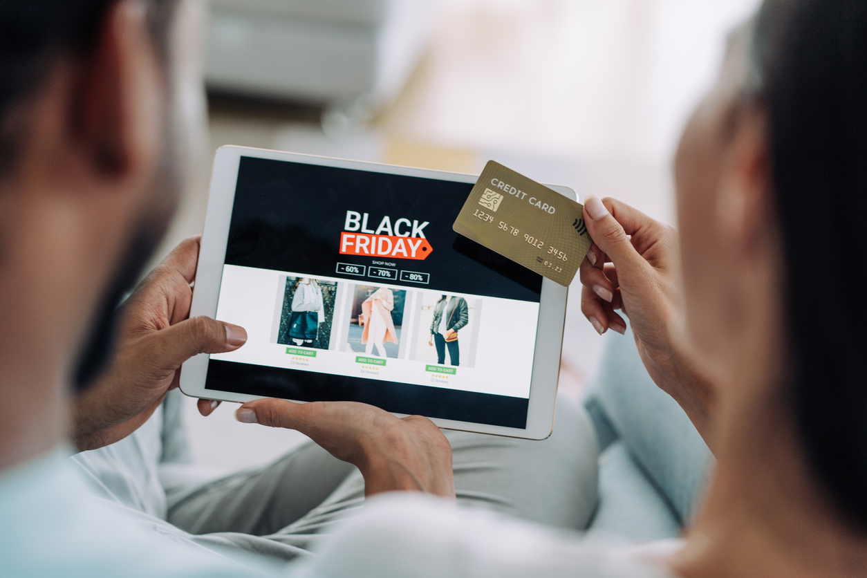 Close-up shot of a young couple holding a digital tablet and shopping online on Black Friday at home. Couple shopping online with credit card and digital tablet.