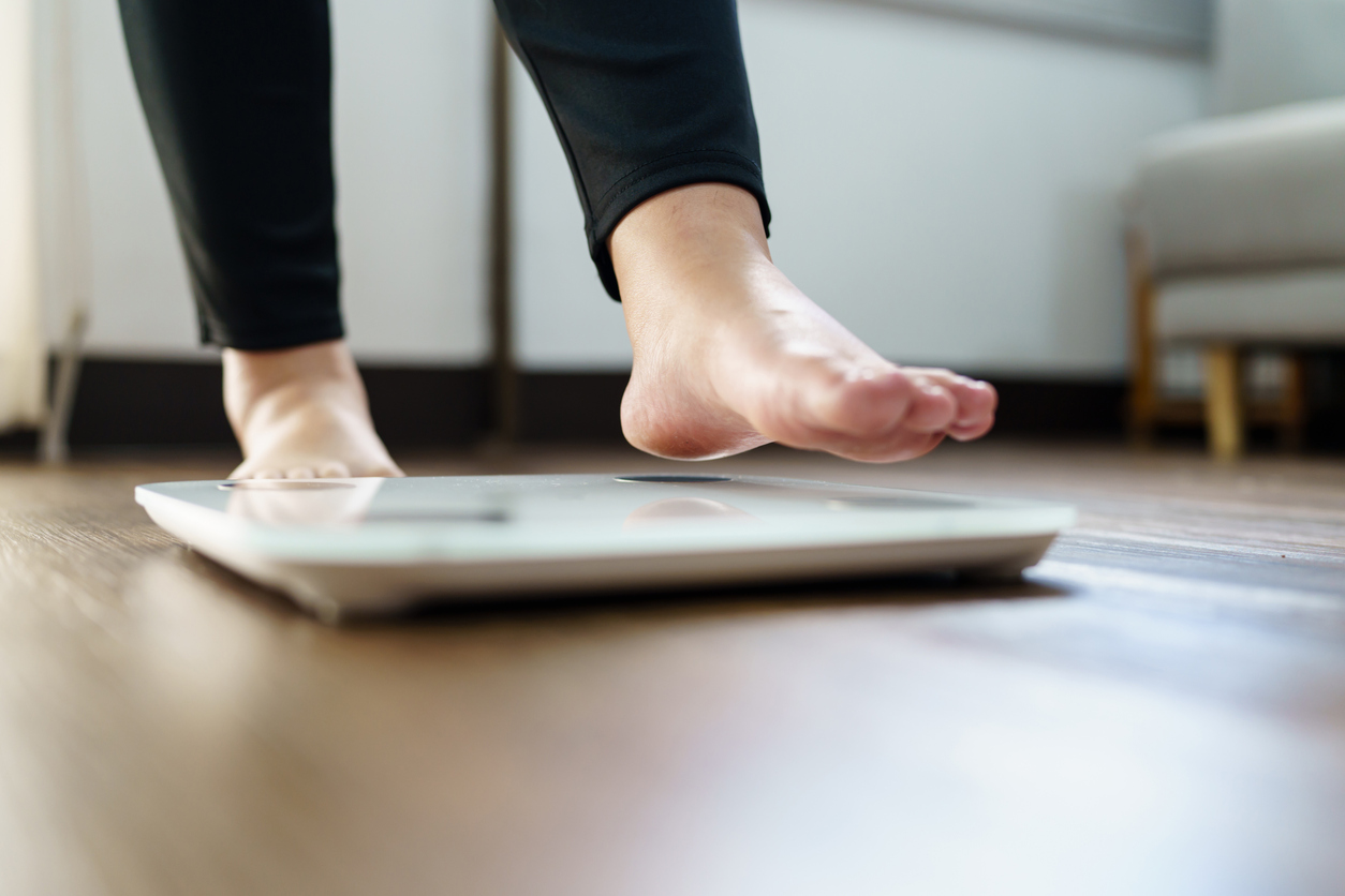 Obese Woman with fat upset bored of dieting Weight loss fail  Fat diet and scale sad asian woman on weight scale at home weight control