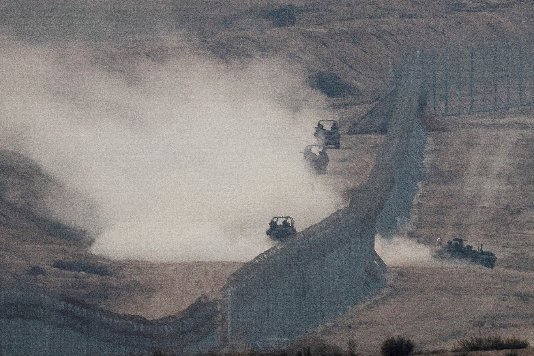 Military vehicles manoeuvre next to a fence, as seen from the Israeli side of the border with Gaza, November 5, 2023. REUTERS