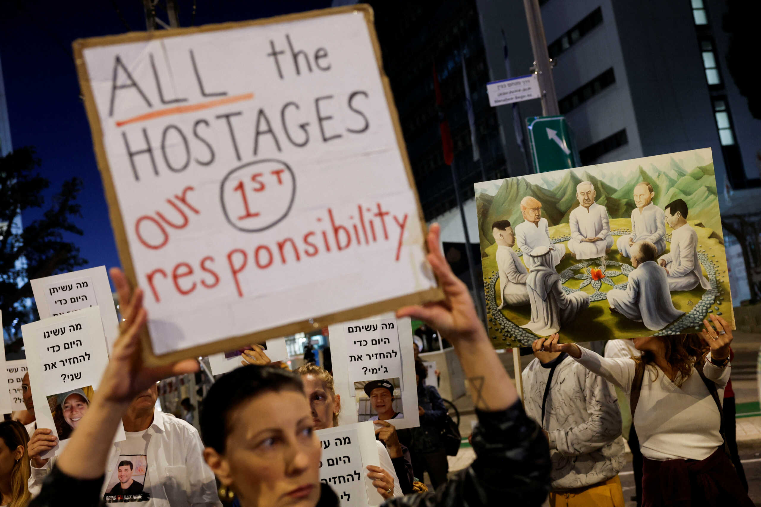 Protesters hold signs demanding the liberation of hostages who are being held in the Gaza Strip after they were seized by Hamas gunmen on October 7, in Tel Aviv, Israel November 21, 2023. REUTERS