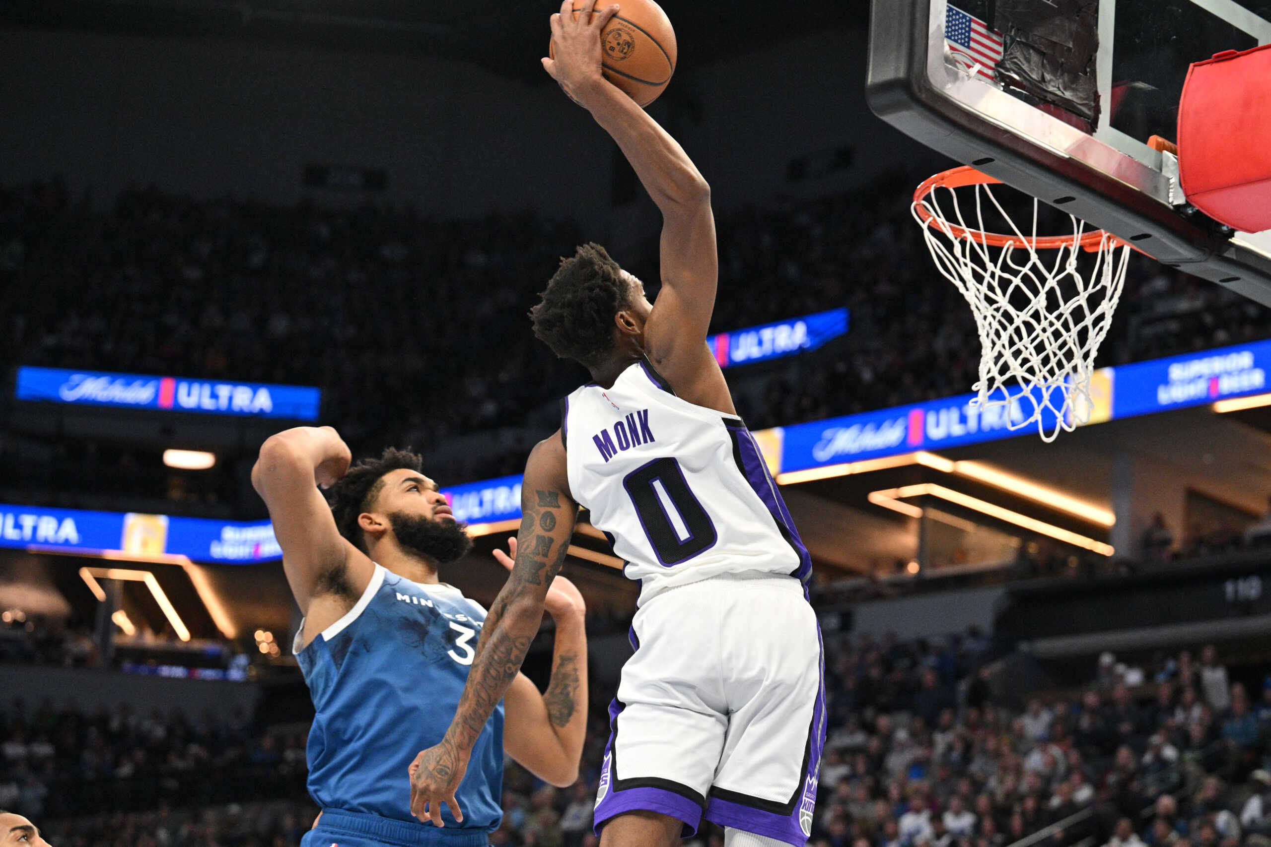 Nov 24, 2023; Minneapolis, Minnesota, USA; Sacramento Kings guard Malik Monk (0) dunks as Minnesota Timberwolves center Karl-Anthony Towns (32) defends during the second quarter at Target Center. Mandatory Credit: Jeffrey Becker-USA TODAY Sports