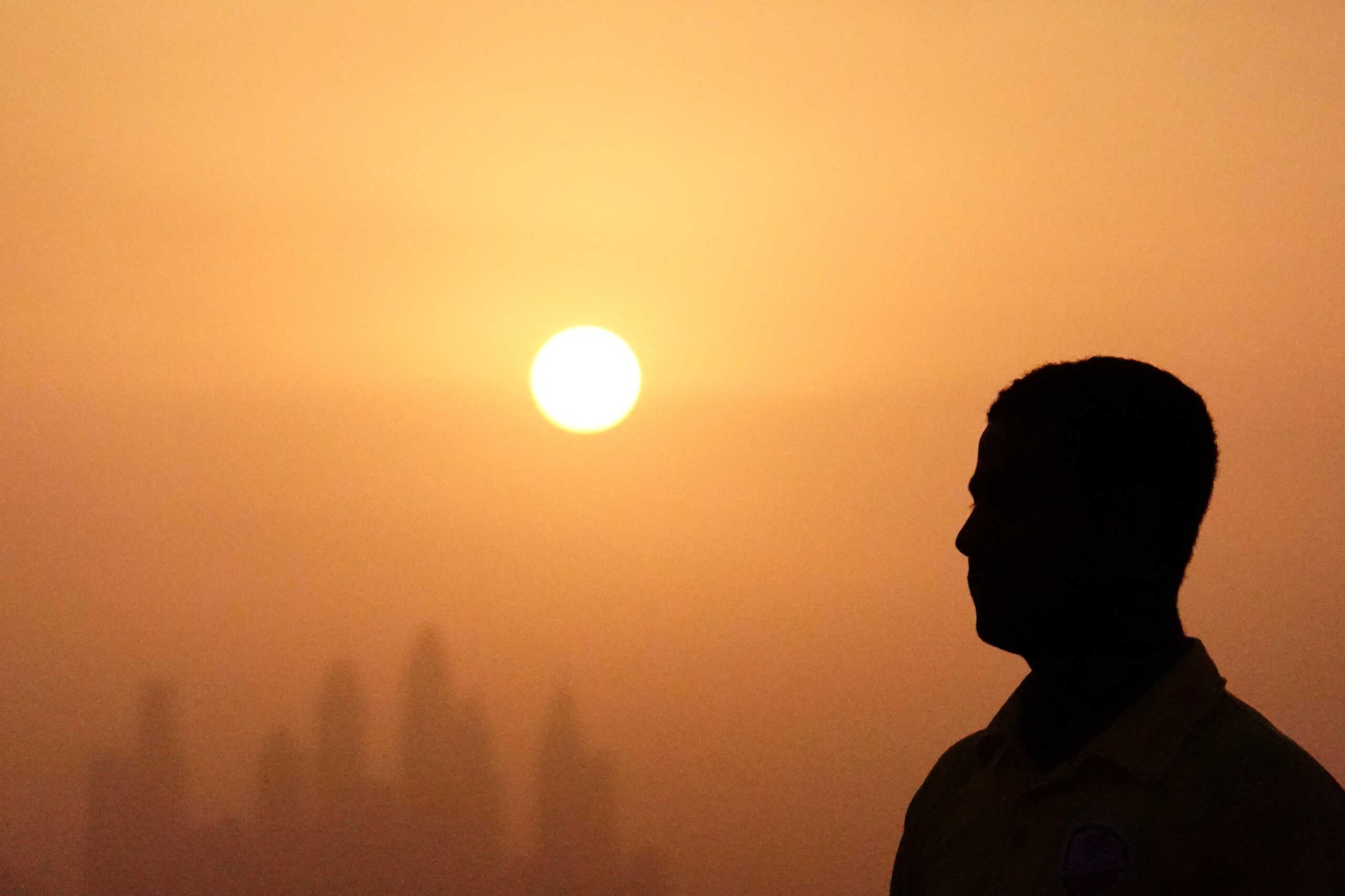 FILE PHOTO: Lifeguard Mohamed stands near a swimming pool while the sun sets over Dubai, United Arab Emirates, August 12, 2023. REUTERS