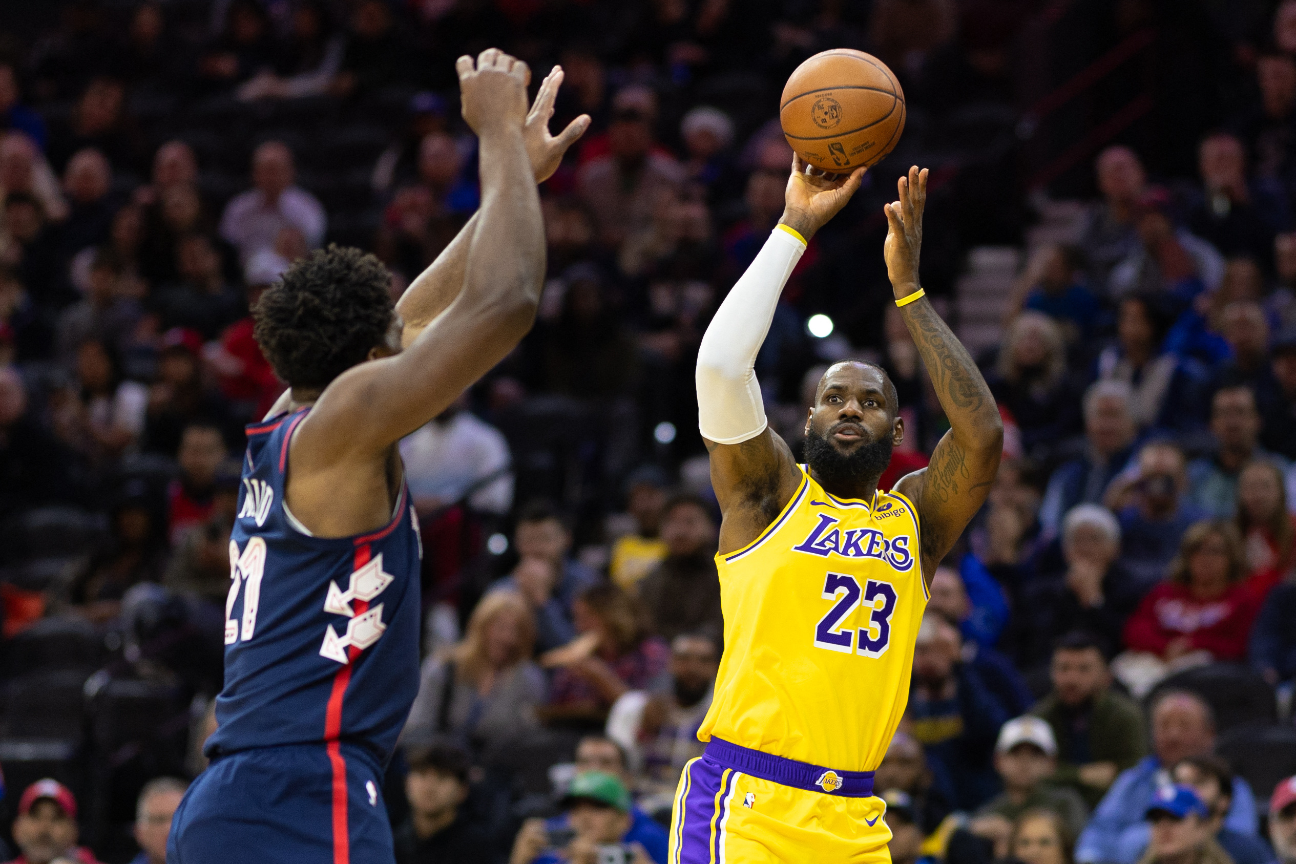 Nov 27, 2023; Philadelphia, Pennsylvania, USA; Los Angeles Lakers forward LeBron James (23) scores a three pointer past Philadelphia 76ers center Joel Embiid (21) during the first quarter at Wells Fargo Center. Mandatory Credit: Bill Streicher-USA TODAY Sports