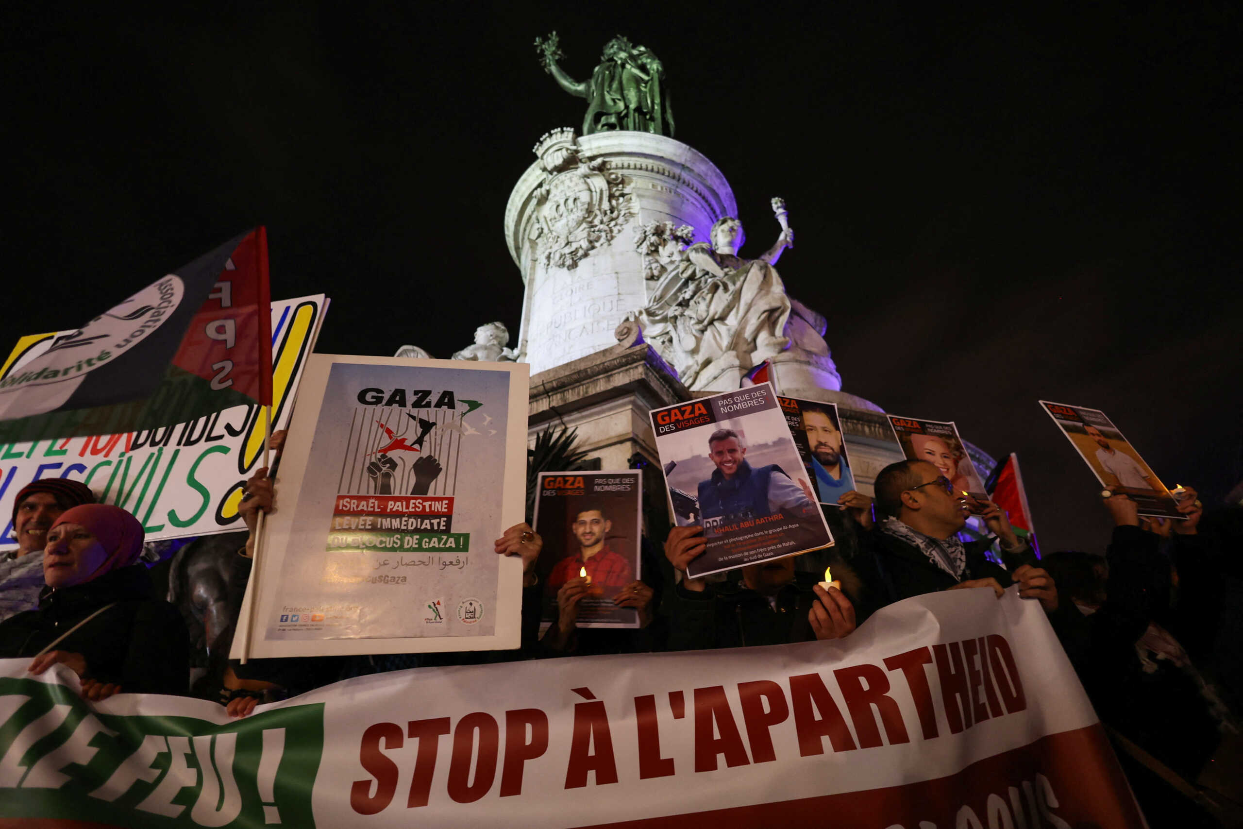 People hold flameless plastic candles and banners during a gathering in solidarity with Palestinians in Gaza and in support of an immediate ceasefire amid the ongoing conflict between Israel and Hamas, at the Place de la Republique in Paris, France, November 2, 2023. REUTERS