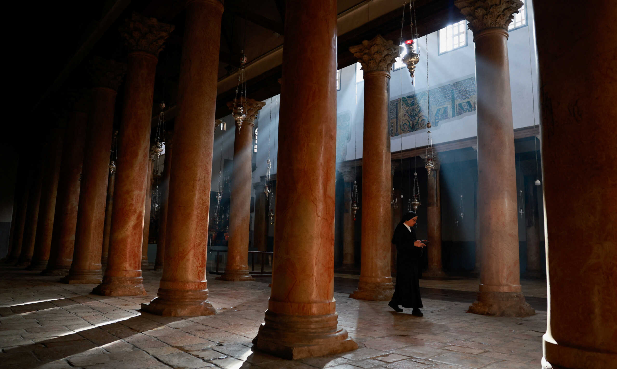A nun walks at the Church of the Nativity on the day of the launch of the beginning of the Christmas season, as the conflict between Israel and Palestinian Islamist group Hamas continues, in Bethlehem in the Israeli-occupied West Bank December 2, 2023. REUTERS