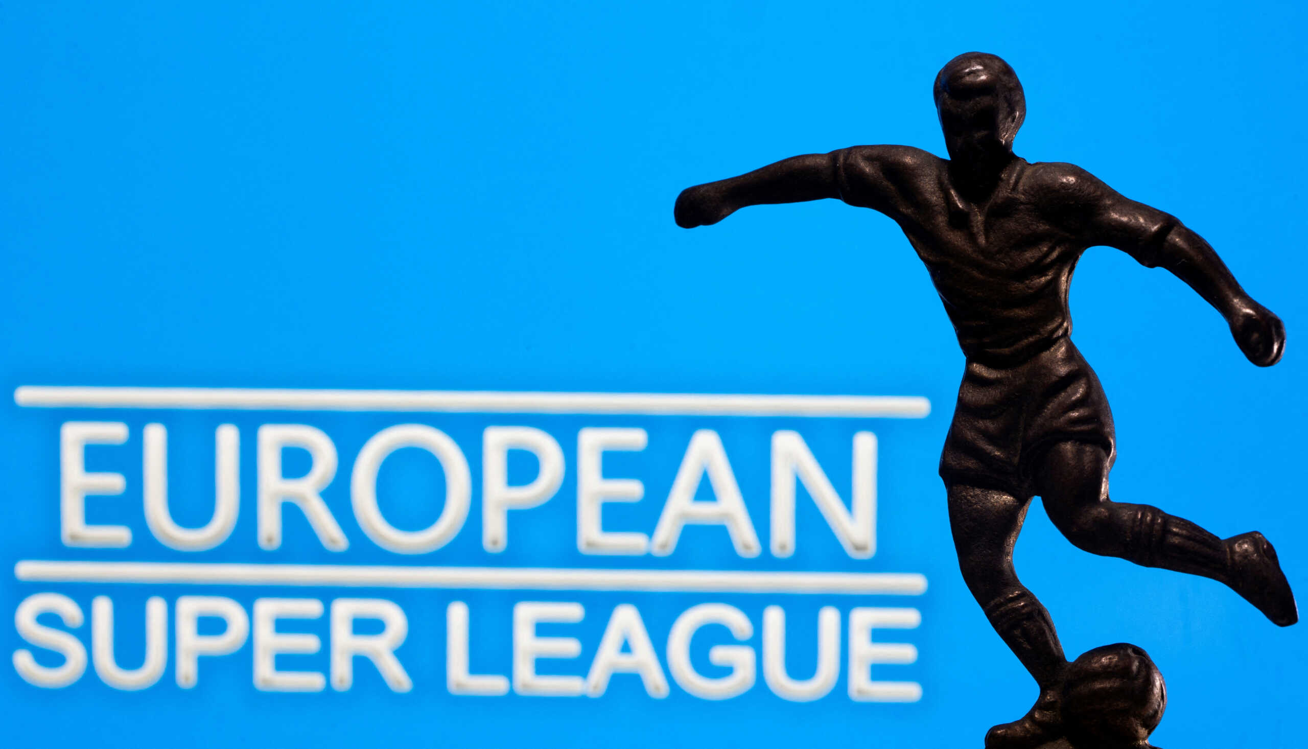 FILE PHOTO: A metal figure of a football player with a ball is seen in front of the words "European Super League" in this illustration taken April 20, 2021. REUTERS