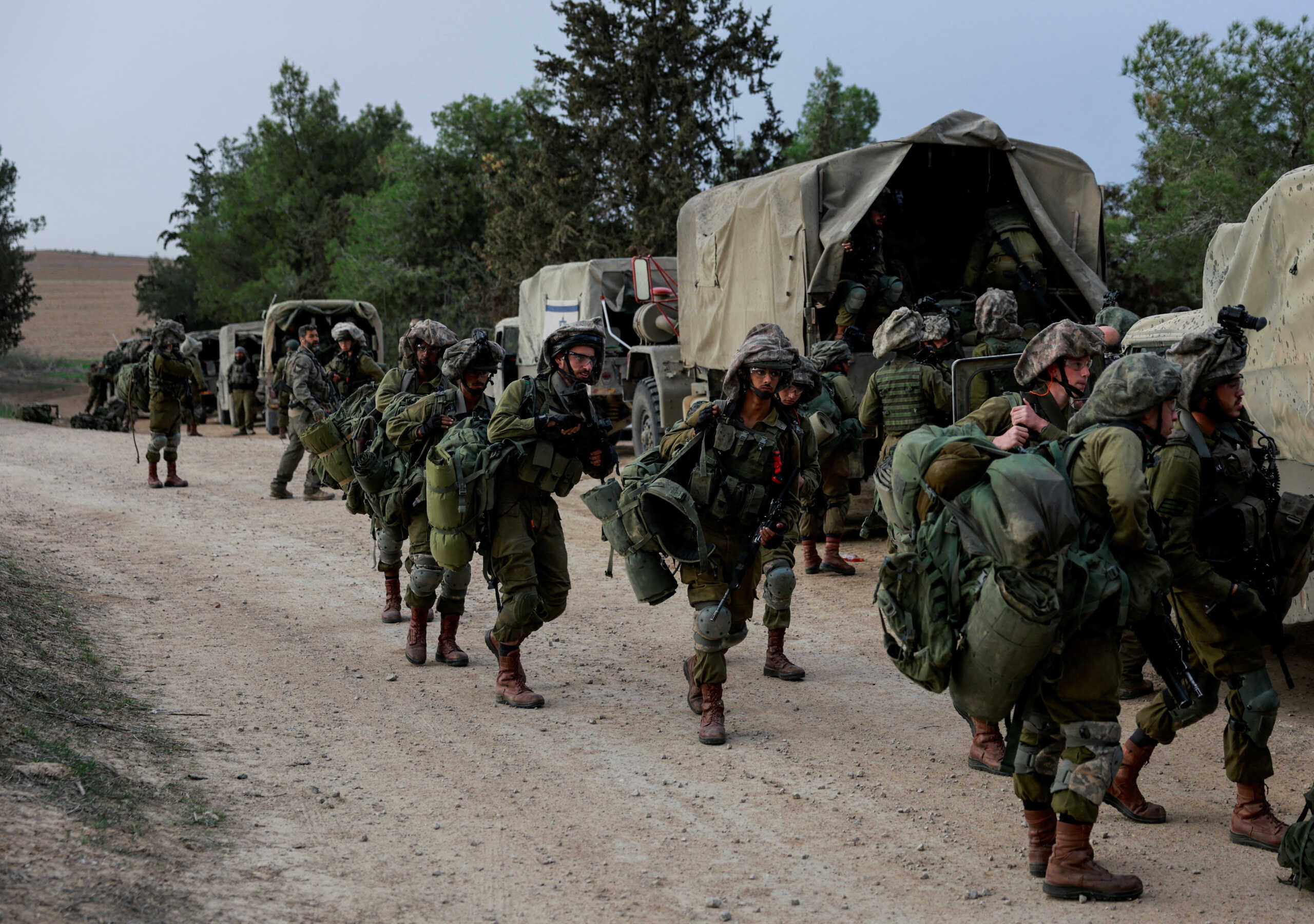Israeli soldiers gather on the Israeli side near the border with Gaza, amid the ongoing conflict between Israel and the Palestinian Islamist group Hamas, as seen from southern Israel, December 12, 2023. REUTERS
