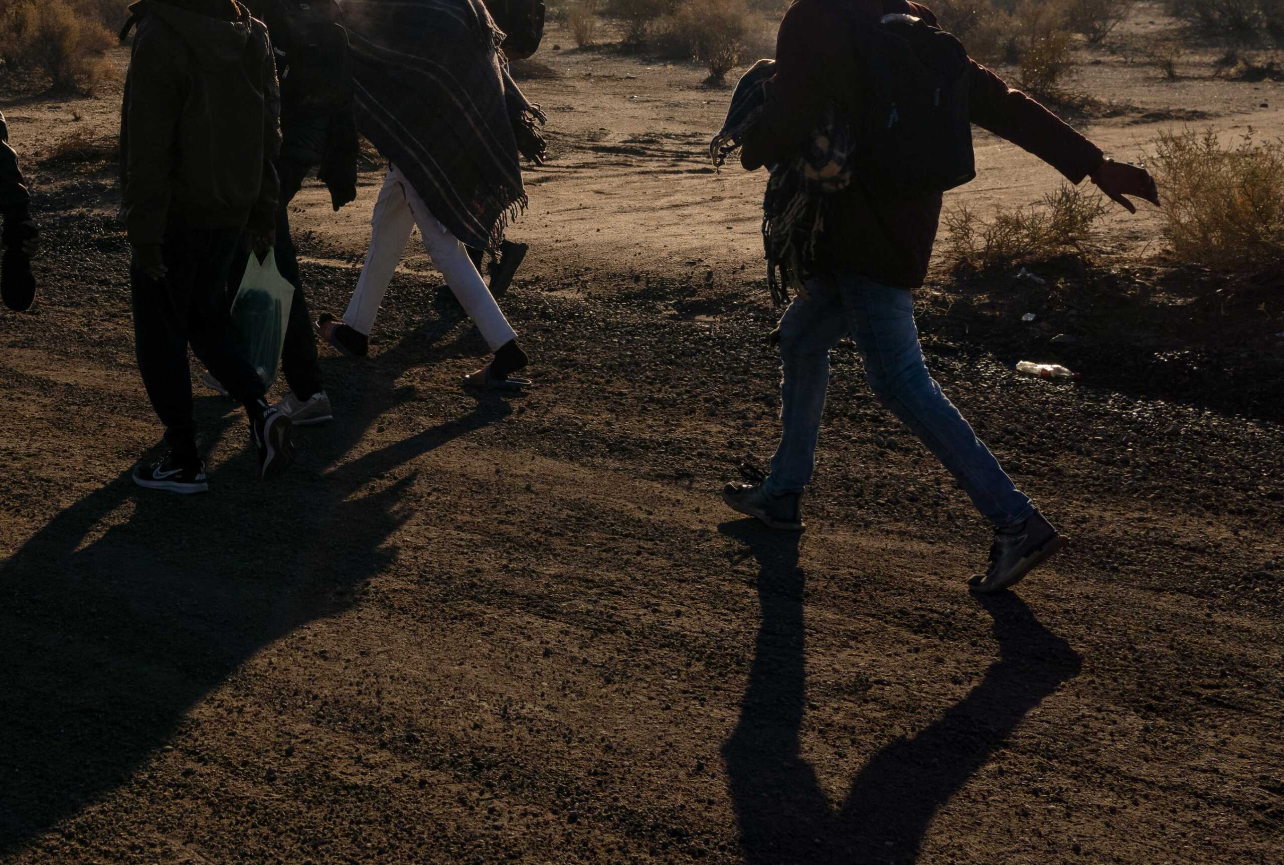 Migrants walk to a processing facility as directed by Border Patrol at the U.S.-Mexico border near Lukeville, Arizona, U.S., December 25, 2023.   REUTERS