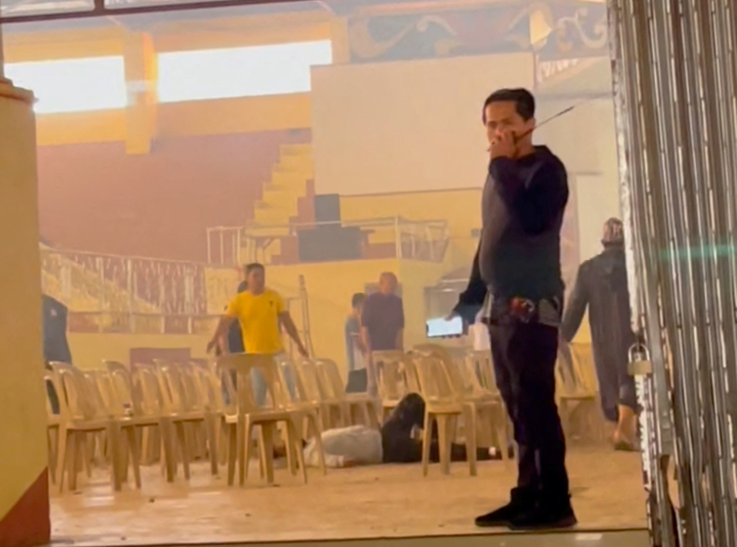 A person lies on the floor while rescuers work at the scene of an explosion that occurred during a Catholic Mass in a gymnasium at Mindanao State University in Marawi, Lanao Del Sur province, Philippines, December 3, 2023 in this screengrab obtained from social media video. Julkiflie Lampaco Hadji-Taher