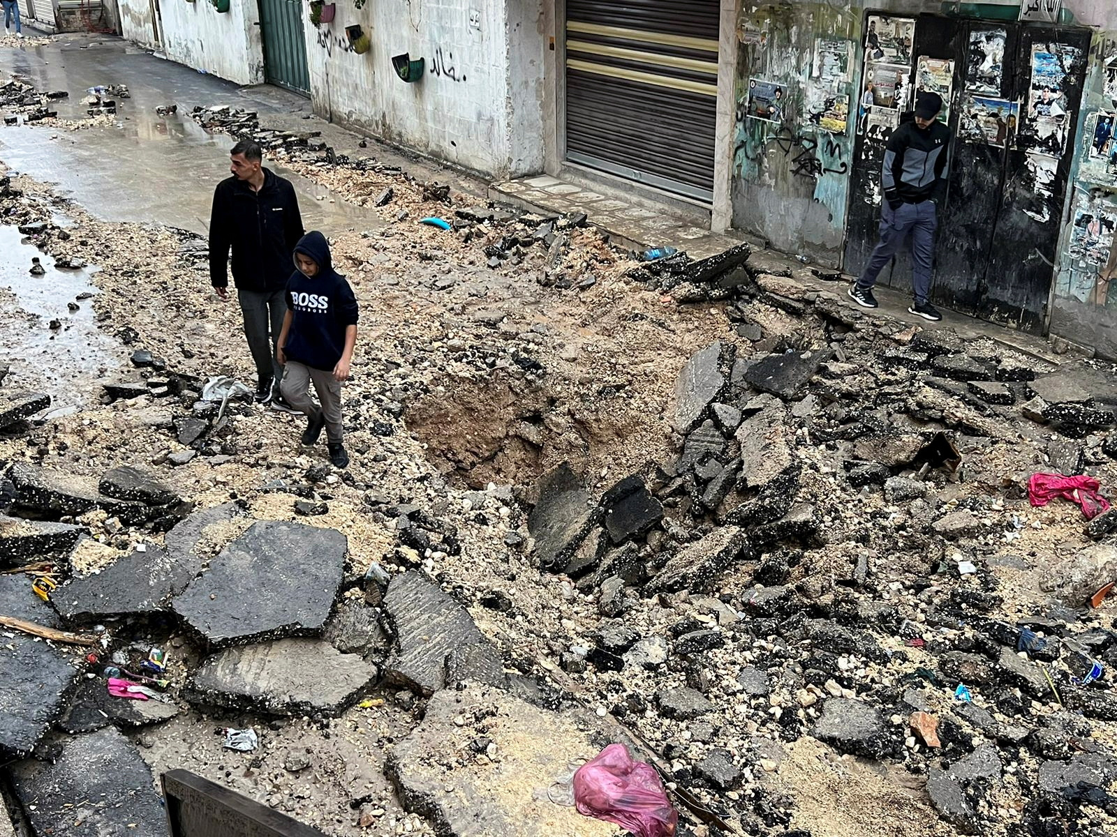Palestinians walk on a damaged road after Israeli forces raided Jenin refugee camp, in Jenin in the Israeli-occupied West Bank November 19, 2023. REUTERS