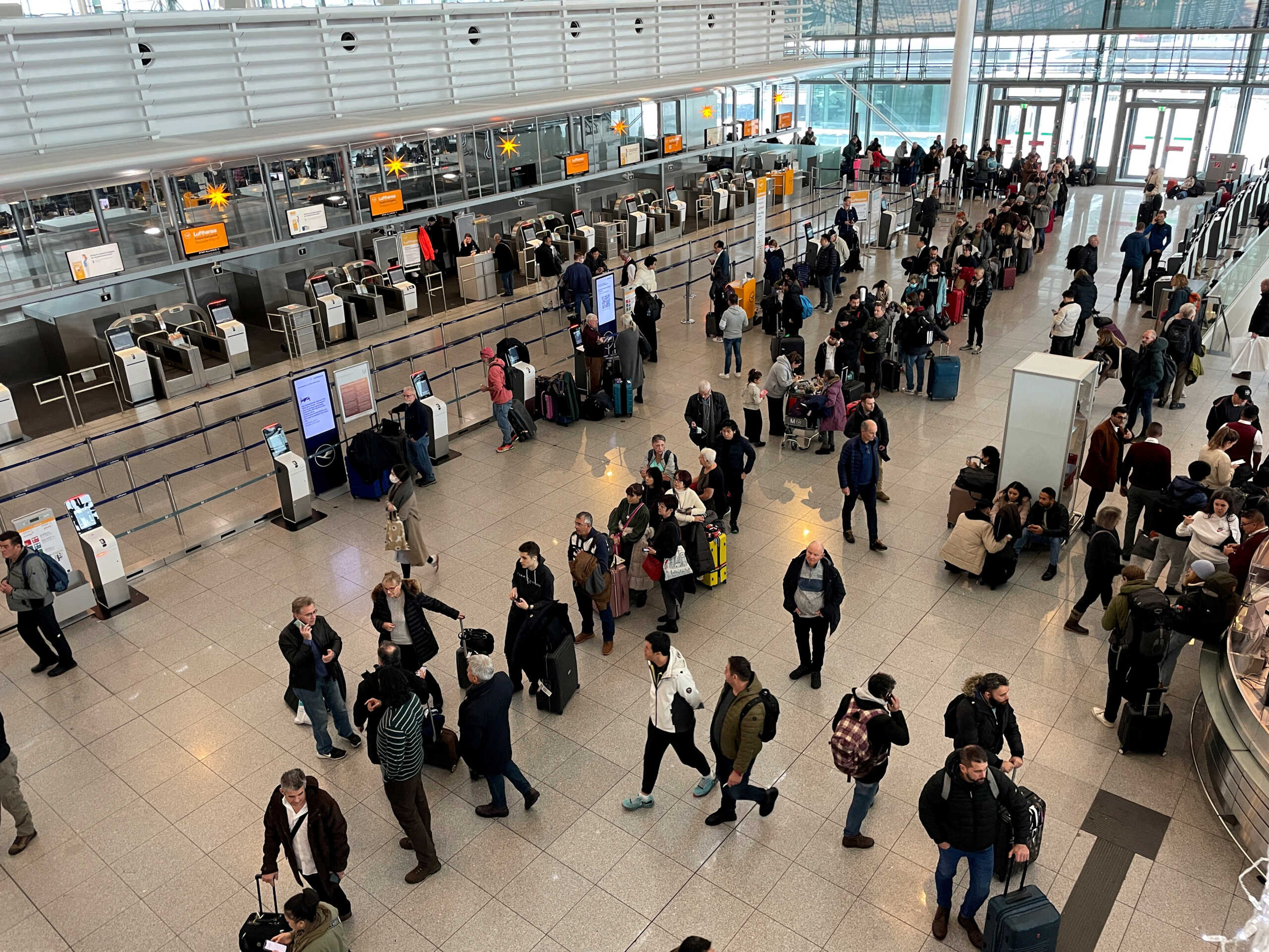 Passengers stand in line at Munich's airport after heavy snowfall hit Bavaria and its capital Munich, Germany, December 2, 2023. The German Bundesliga soccer match FC Bayern Munich v 1. FC Union Berlin had to be cancelled, trains halted and the airport closed because of the the weather condition.     REUTERS