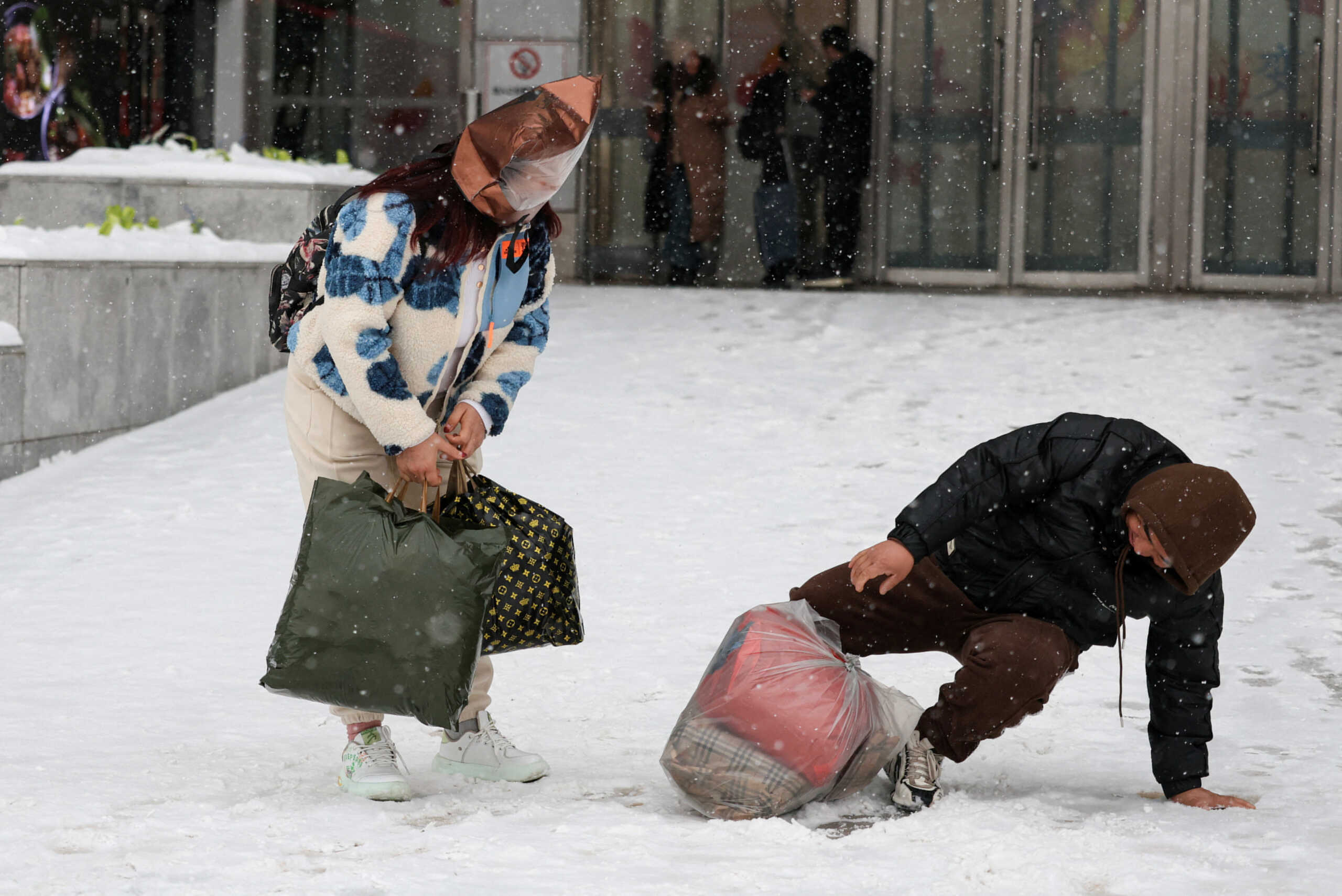 A man falls on a slope amid snowfall in Beijing, China December 14, 2023. REUTERS