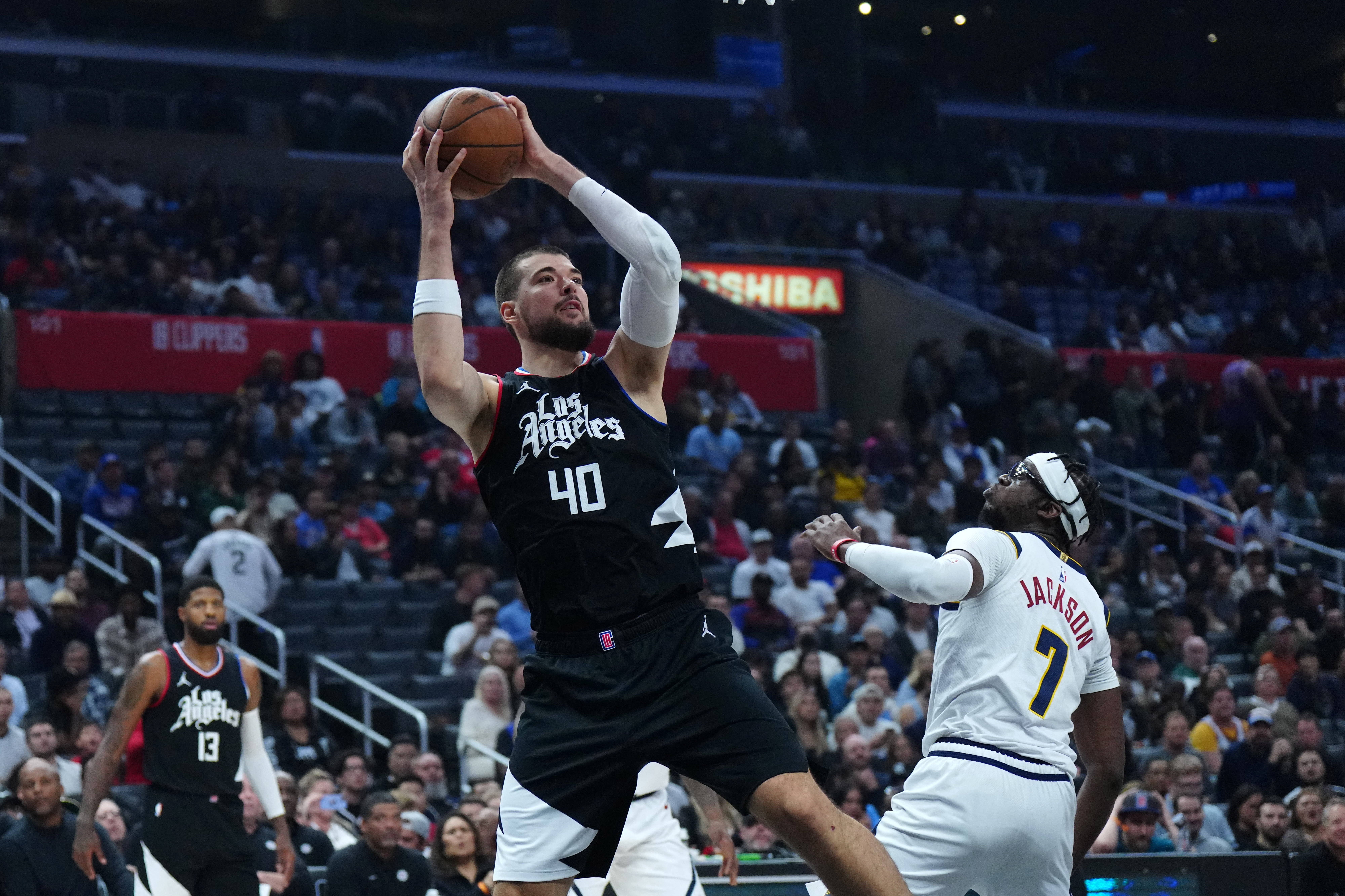Dec 6, 2023; Los Angeles, California, USA; LA Clippers center Ivica Zubac (40) shoots the ball against Denver Nuggets guard Reggie Jackson (7) in the first half at Crypto.com Arena. Mandatory Credit: Kirby Lee-USA TODAY Sports