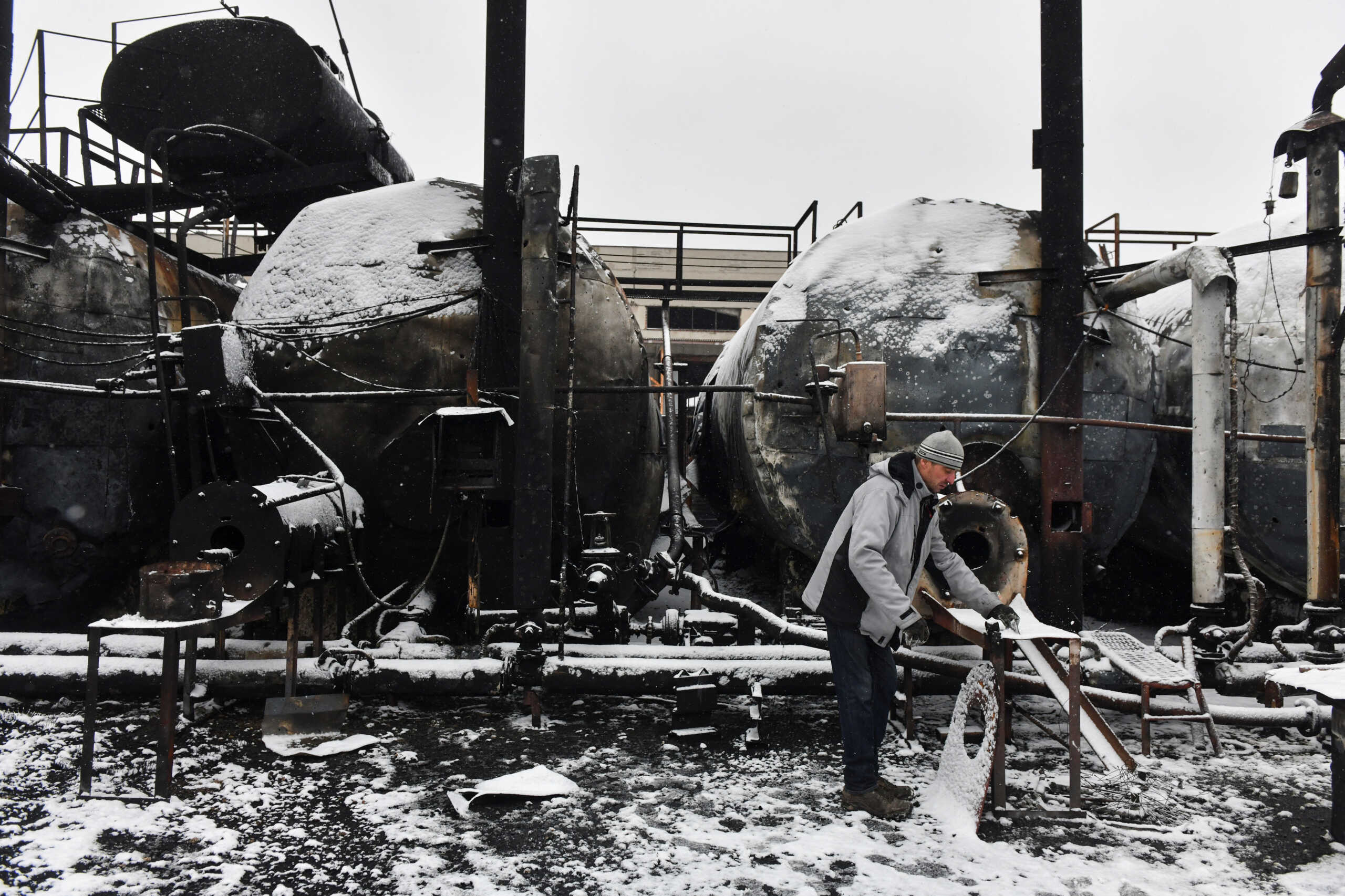 A man inspects damage at an oil depot hit by recent shelling in the course of Russia-Ukraine conflict in Donetsk, Russian-controlled Ukraine, December 7, 2023. REUTERS