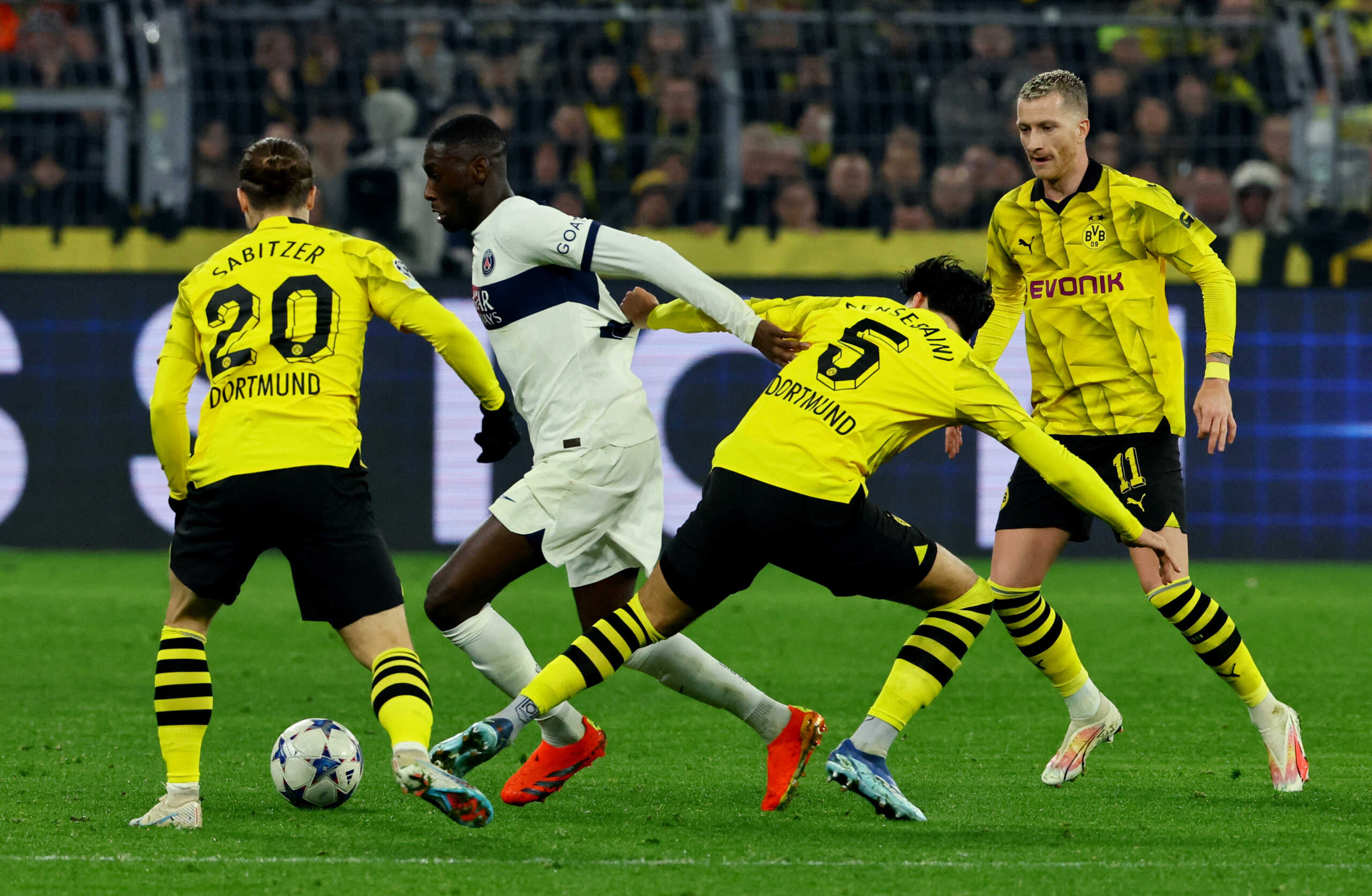 Soccer Football - Champions League - Group F - Borussia Dortmund v Paris St Germain - Signal Iduna Park, Dortmund, Germany - December 13, 2023 Paris St Germain's Randal Kolo Muani in action with Borussia Dortmund's Marcel Sabitzer and Ramy Bensebaini REUTERS