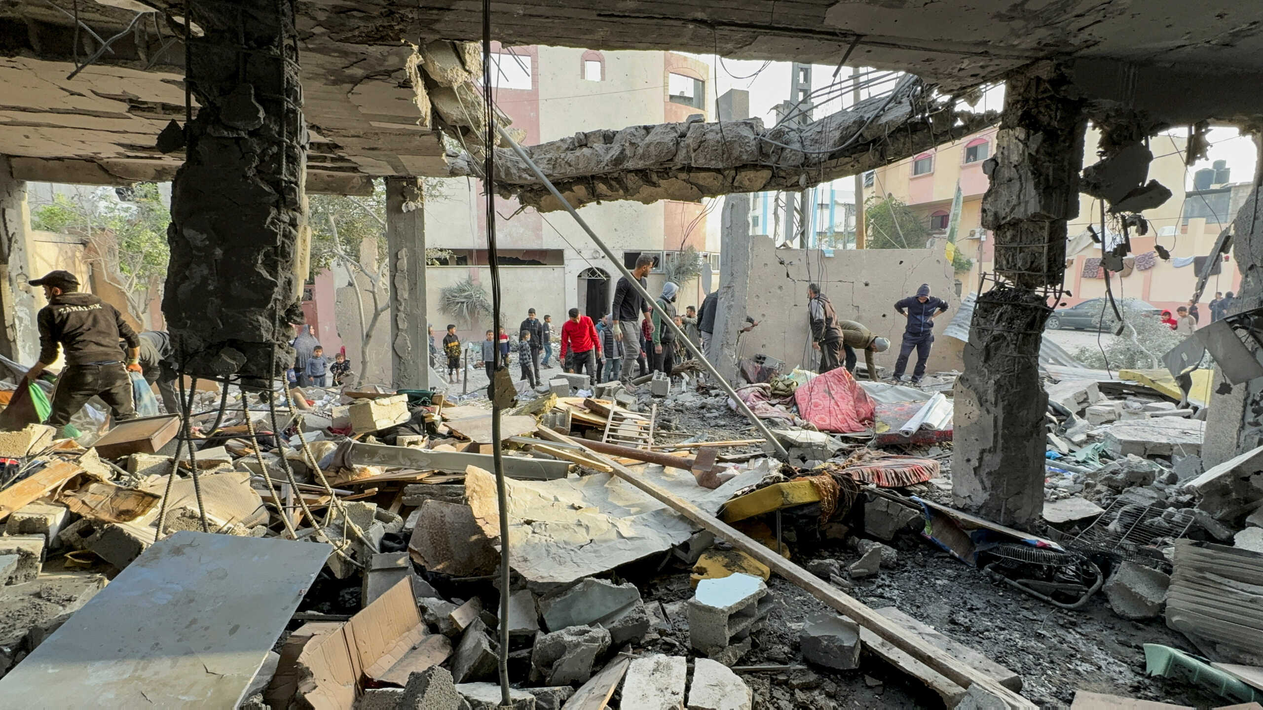 Palestinians gather at the site of an Israeli strike on a house, amid the ongoing conflict between Israel and Palestinian Islamist group Hamas, in Khan Younis in the southern Gaza Strip, December 20, 2023. REUTERS