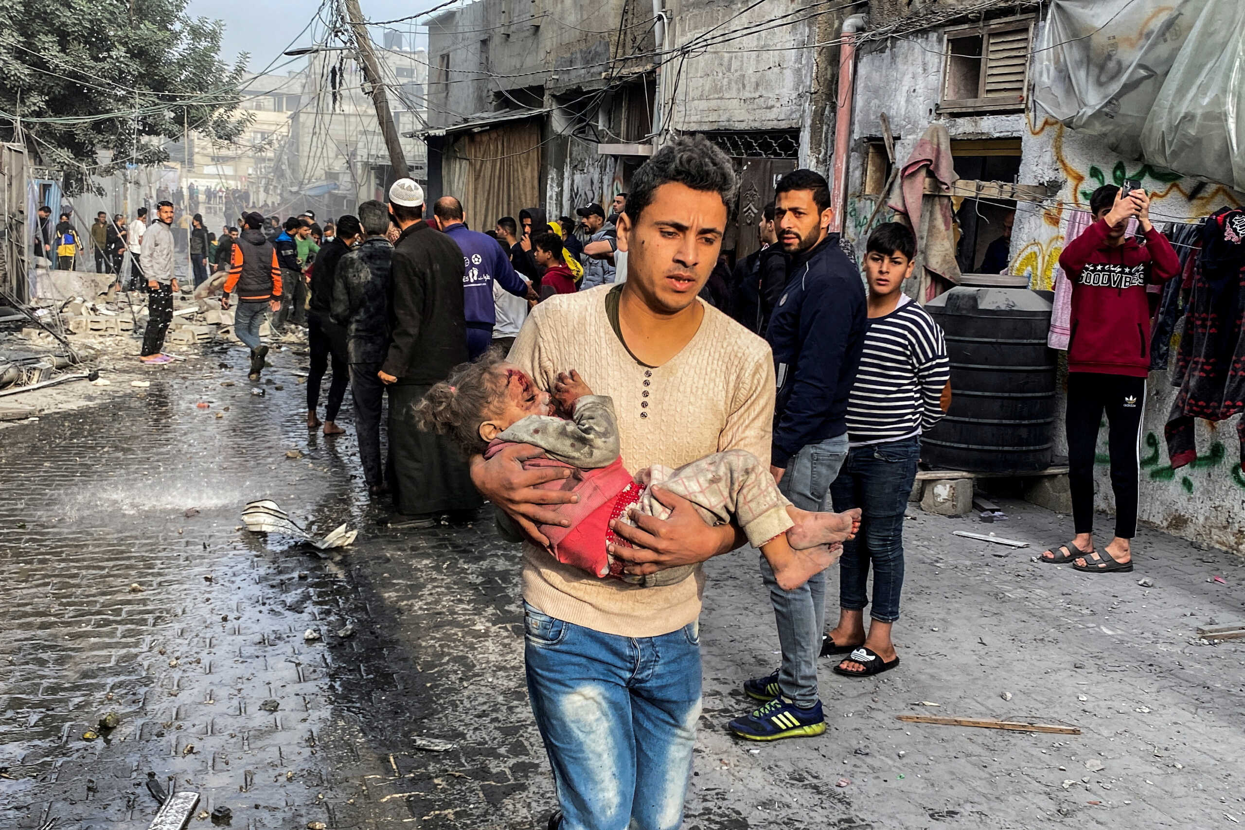 A Palestinian carries a casualty following an Israeli strike on a house, after a temporary truce between Hamas and Israel expired, in Rafah, in the southern Gaza Strip December 1, 2023. REUTERS