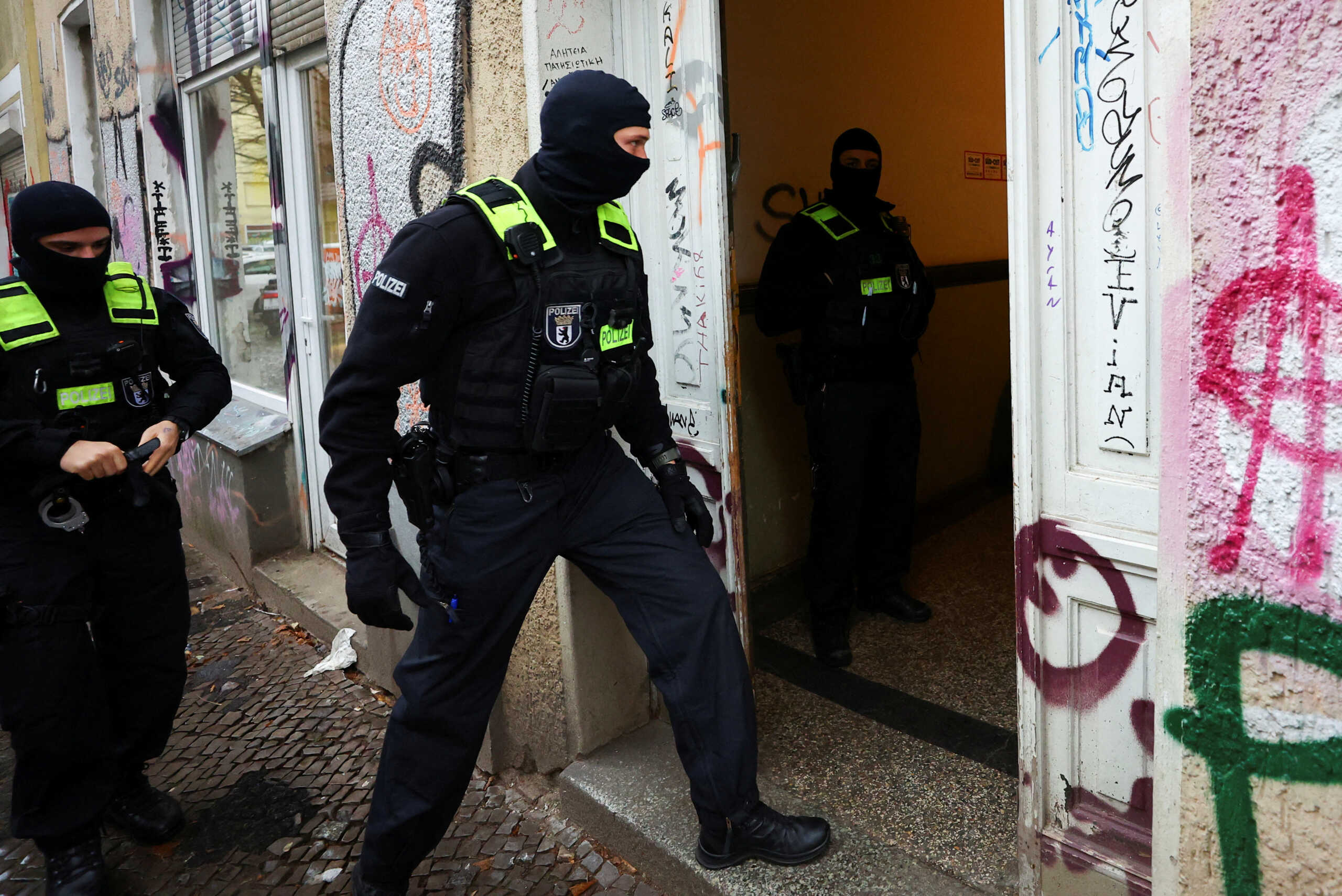 A German police officer enters an apartment building during a raid against people supporting the Palestinian Islamist group Hamas, in Berlin, Germany, November 23, 2023. REUTERS