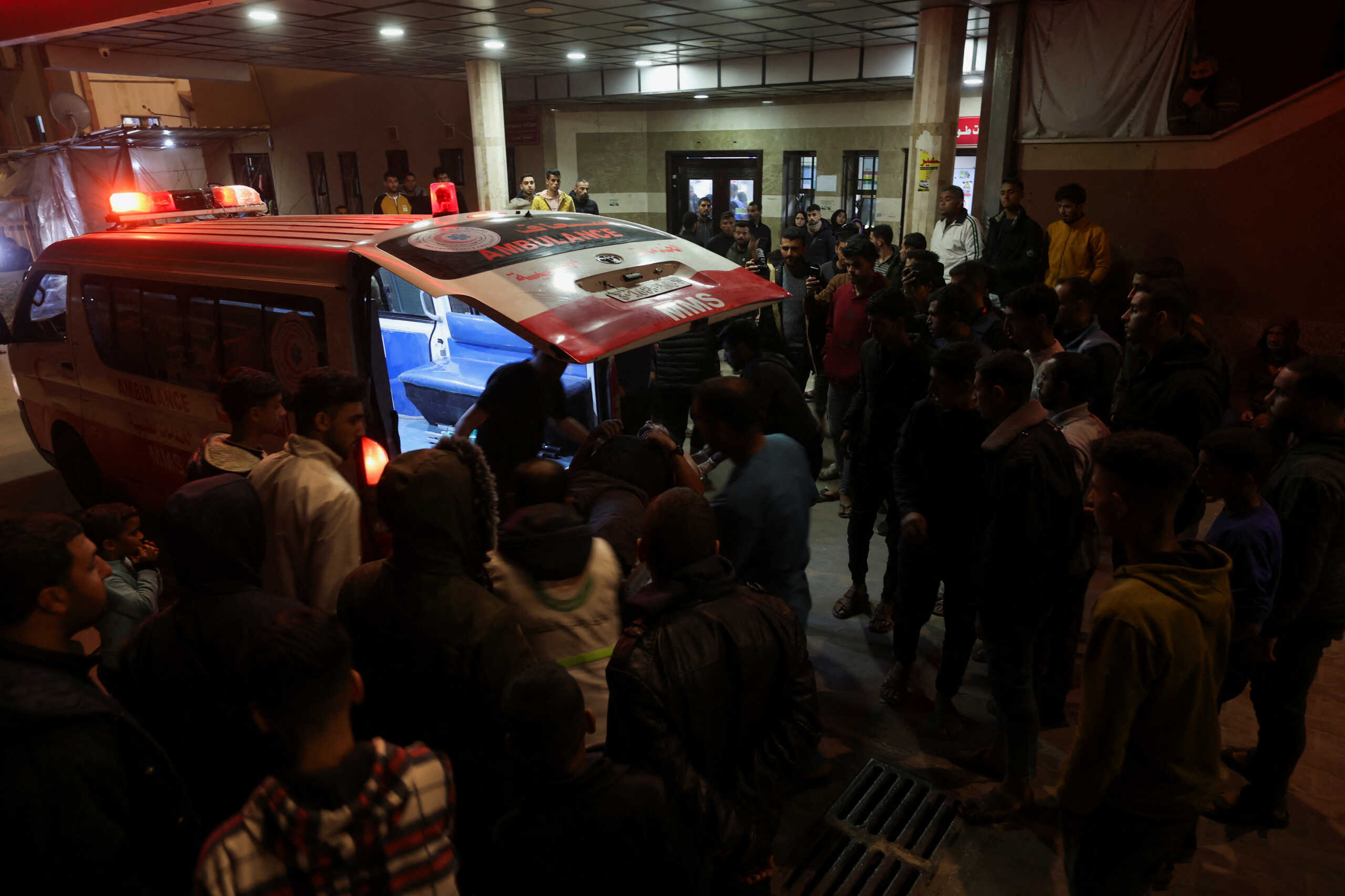 A wounded Palestinian is assisted from an ambulance at Nasser hospital following Israeli strikes, amid the ongoing conflict between Israel and Palestinian Islamist group Hamas, in Khan Younis, December 12, 2023. REUTERS